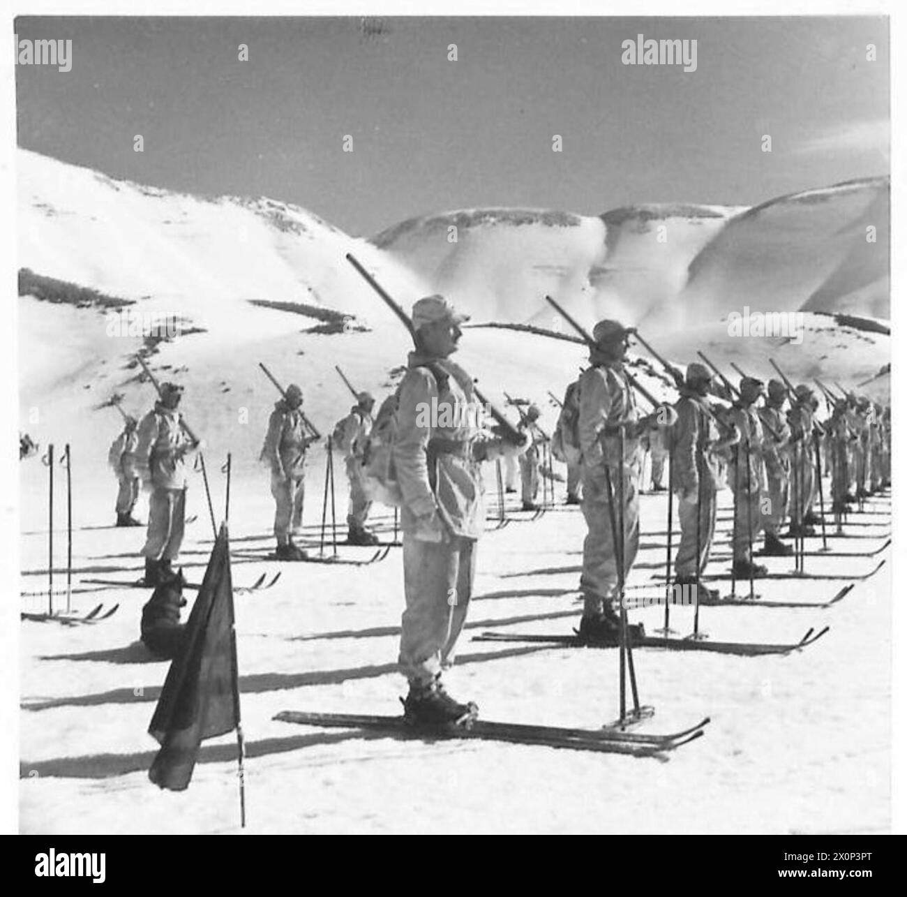 Les troupes de ski de l'armée britannique défilent avec les armes sur la pente pendant les exercices d'entraînement. La photographie documente la préparation à la guerre hivernale et le développement des compétences militaires. Banque D'Images
