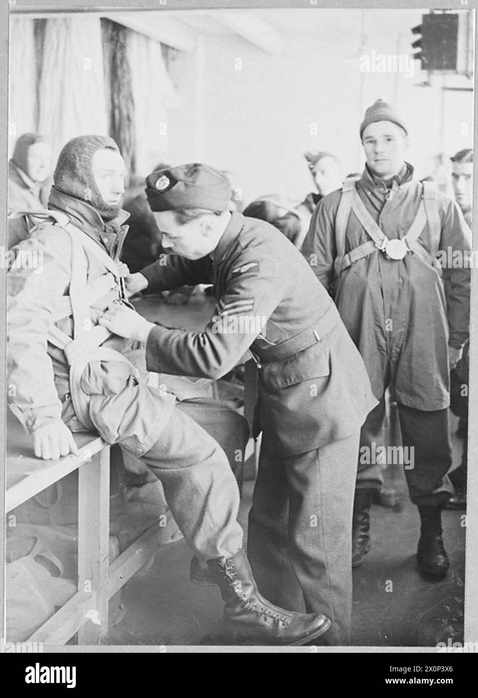 PARACHUTISTES BRITANNIQUES : LE SERVICE PREND LA SOIE - scènes dans la cabine d'essayage où chaque homme a son harnais correctement ajusté et testé pour lequel il signe le journal de bord du parachute. Négatif photographique, Royal Air Force Banque D'Images