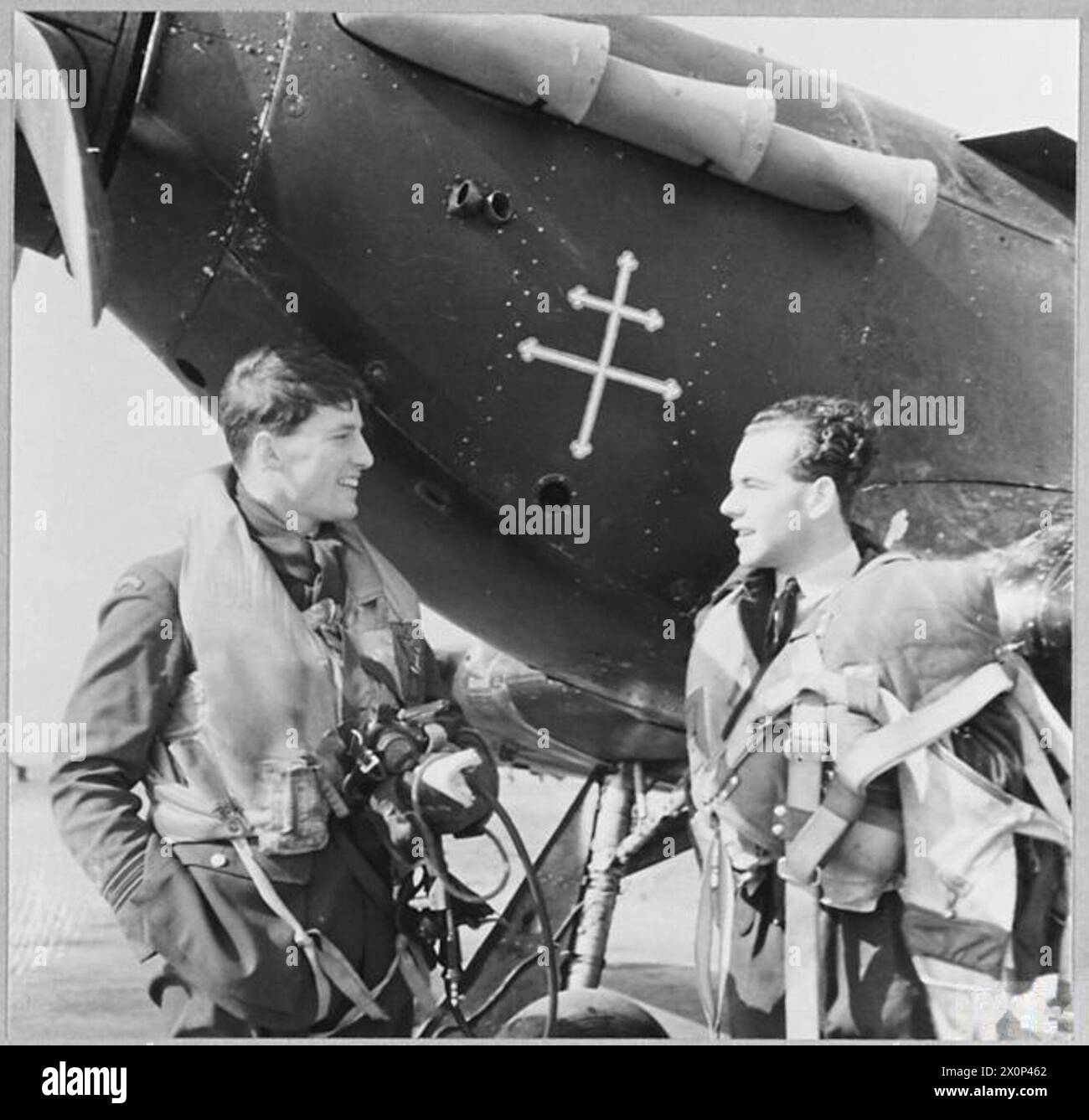 Le C.O. parle avec un pilote français libre de l’escadron de chasse britannique de Chine ; l’avion Hurricane du pilote arbore l’emblème de la Croix de Lorraine. Banque D'Images