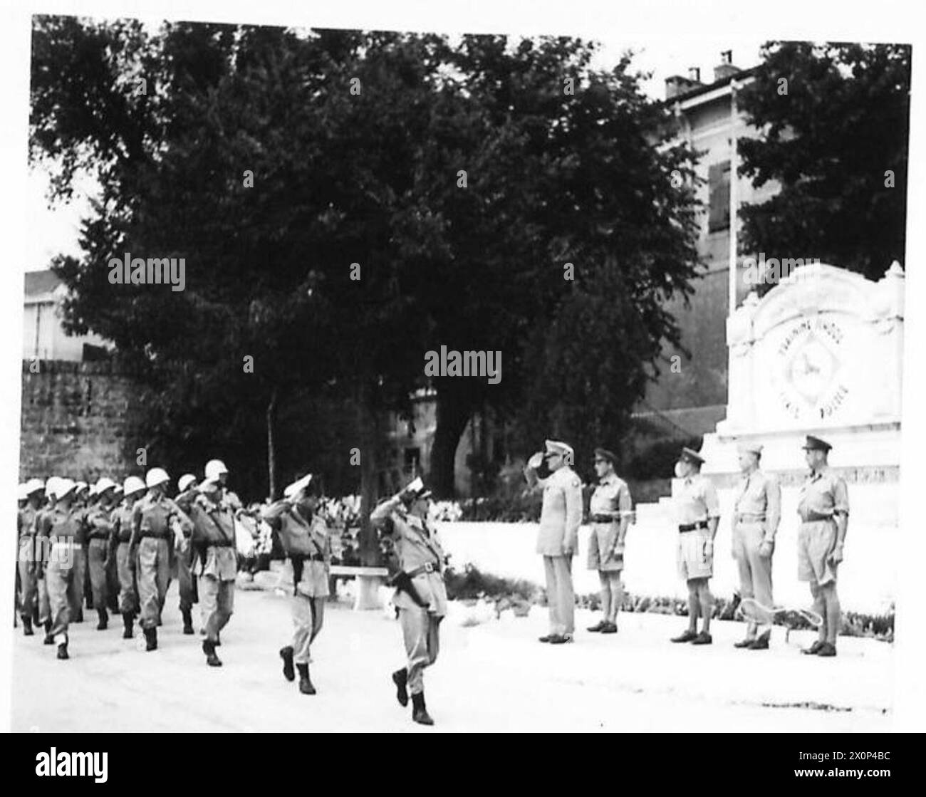 Photographie montrant l'escouade de tête de la police V.G. marchant devant la base de salutation où le colonel Bowman prend le salut, sous l'armée britannique. Banque D'Images