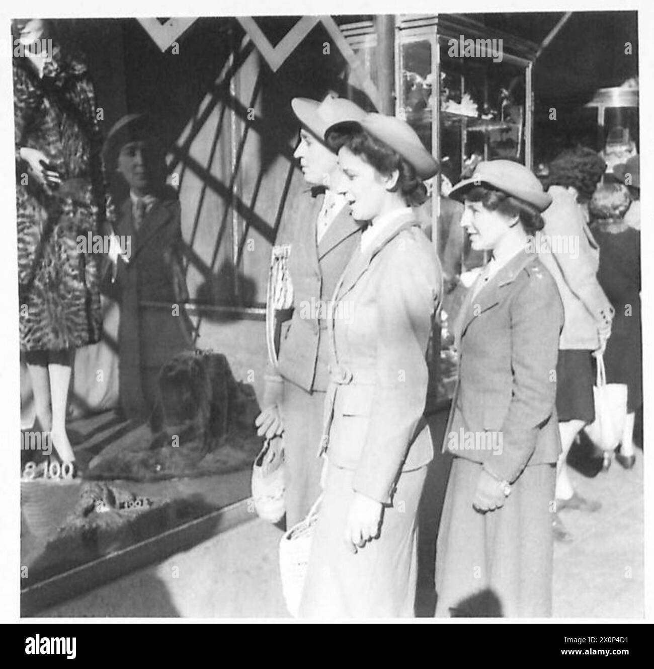 Sœur Langridge et deux collègues observent des vêtements dans une vitrine de magasin pendant une journée dans la vie d’une infirmière en Afrique du Nord. Banque D'Images