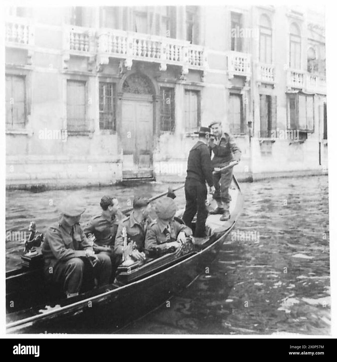 Le Cpl Fenn reçoit une instruction sur la navigation en gondole à Venise pendant que d'autres soldats observent. Banque D'Images