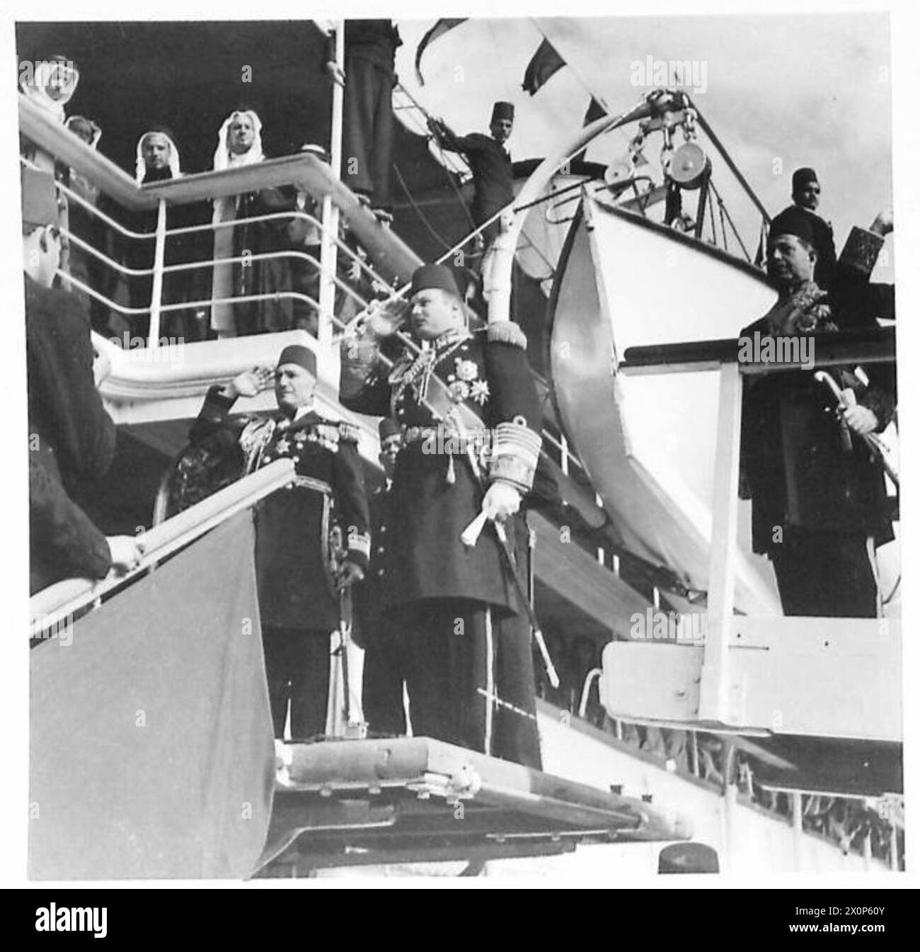Le roi Farouk salue tandis que l'hymne national est joué dans le rôle du roi Abd al-'Aziz Ibn Saoud à bord du yacht royal lors d'une cérémonie d'accueil en Égypte. Banque D'Images