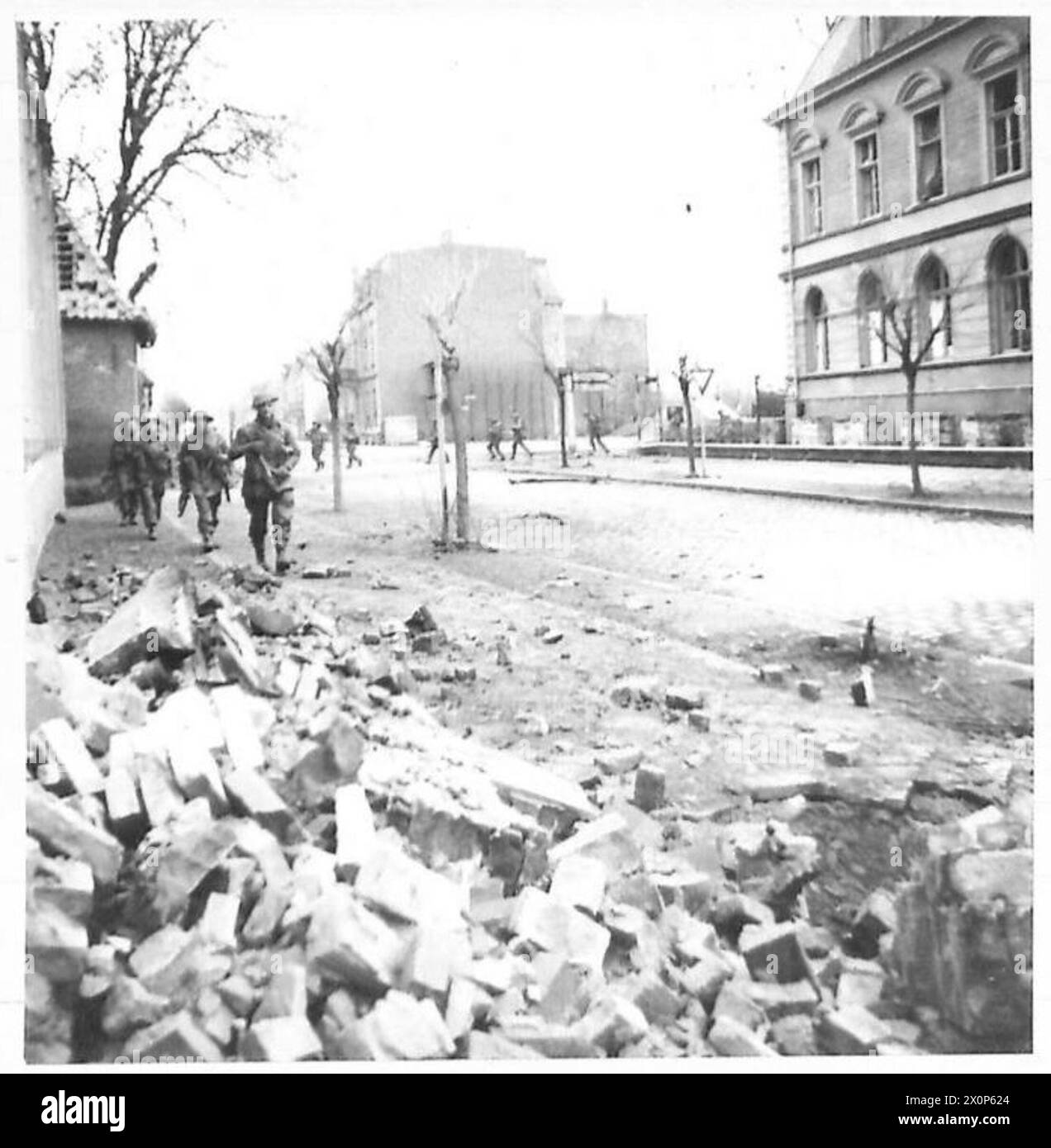 L'infanterie du 2e Bataillon Monmouthshire Regiment se déplace dans les rues de Bocholt pendant les combats de rue. Négatif photographique de l'armée britannique, 21e groupe d'armées. Banque D'Images