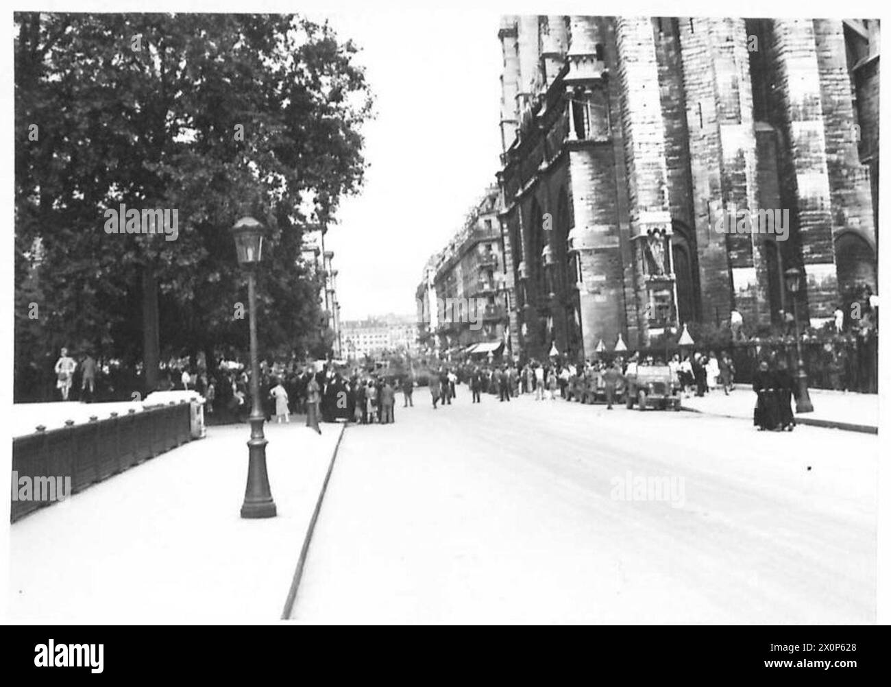 Les Parisiens se rassemblent à notre Dame pour assister à l'arrivée du général de Gaulle, avec des troupes de la division blindée française et des membres du F.F.I. présents. La scène capture la présence civique et militaire pendant la seconde Guerre mondiale à Paris. Banque D'Images