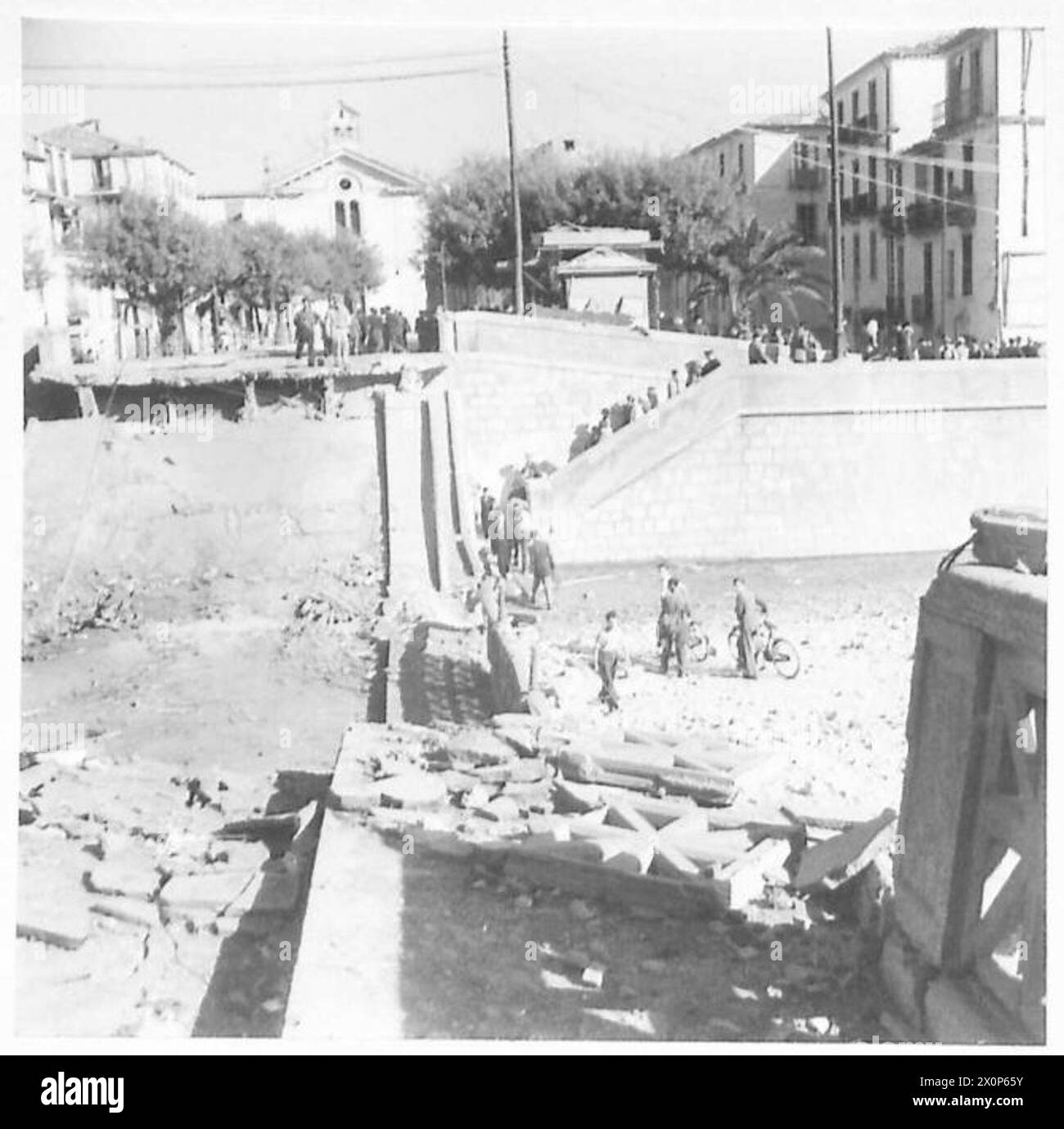 INVASION DE L'ITALIE : HUITIÈME ARMÉE - les Allemands avec une rigueur caractéristique, ont fait sauter ce pont sur la rivière qui coule à travers la ville de Cosenza. Les principaux éléments de la 8e armée avançaient le long des principales routes côtières, de sorte que la principale obstruction causée par cette démolition frappa les habitants de la ville plus que les forces avançant. Les gens devaient descendre dans le lit de la rivière partiellement asséché et traverser l'eau au moyen de planches pour accéder à d'autres parties de la ville. Négatif photographique, Armée britannique Banque D'Images