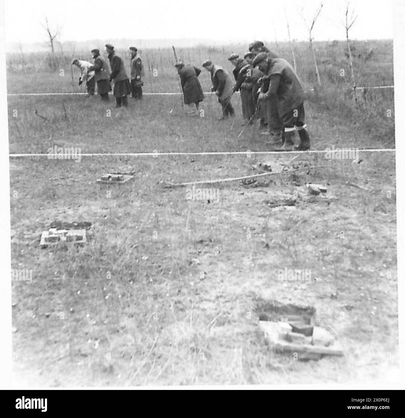 Le personnel de la 682 Artisan Works Company utilise des pointes en acier pour détecter les mines de type boîte dans les défenses côtières près de Ravenne tout en préparant un aérodrome pour la 8e armée. Banque D'Images