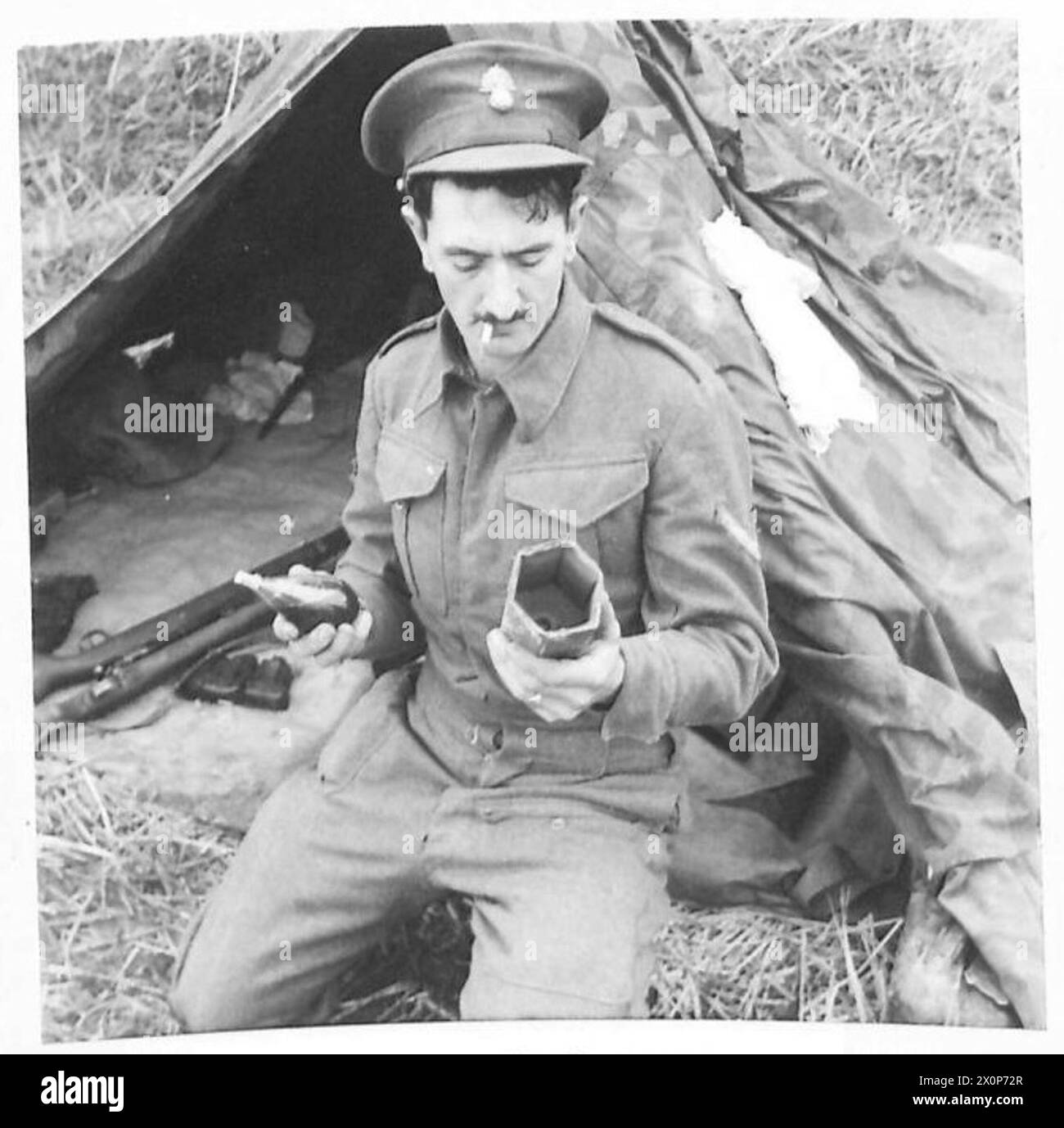 L'ARMÉE BRITANNIQUE EN AFRIQUE DU NORD, EN SICILE, EN ITALIE, DANS LES BALKANS ET EN AUTRICHE 1942-1946 - "Blendkorper" Un composé liquide dans un flacon en verre qui a été utilisé par l'ennemi pour lancer des chars. La fiole a été trouvée près des corps d'Allemands qui ont été tués avant qu'ils ne puissent l'utiliser. Lors de l'impact, le ballon explose et dégage une fumée chimique qui aveugle l'équipage du char. L/CPL. H. Waterman du 1er bn. Royal Fusiliers est vu tenant le flacon. Négatif photographique, Armée britannique Banque D'Images