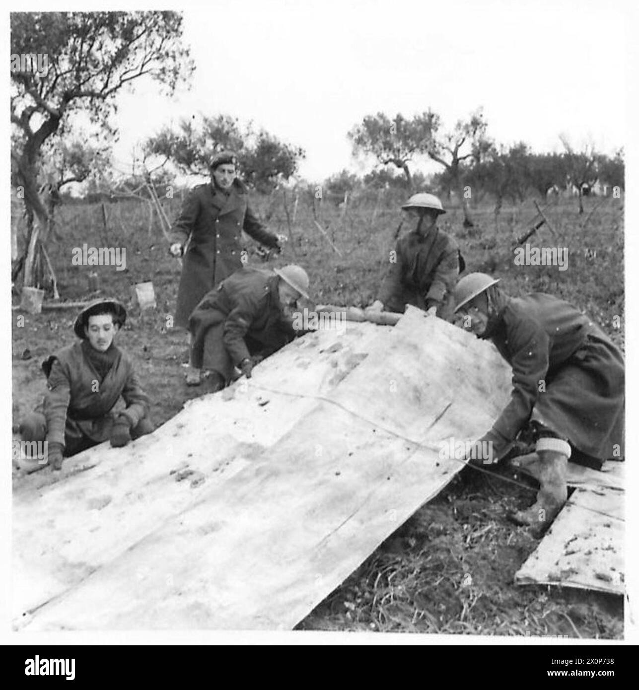 Négatif photographique montrant des membres du 2857e Escadron R.A.F. Regiment déposant de grandes lettres sur toile au sol près d'Ortona, en Italie, pour aider les bombardiers à identifier des cibles. Banque D'Images