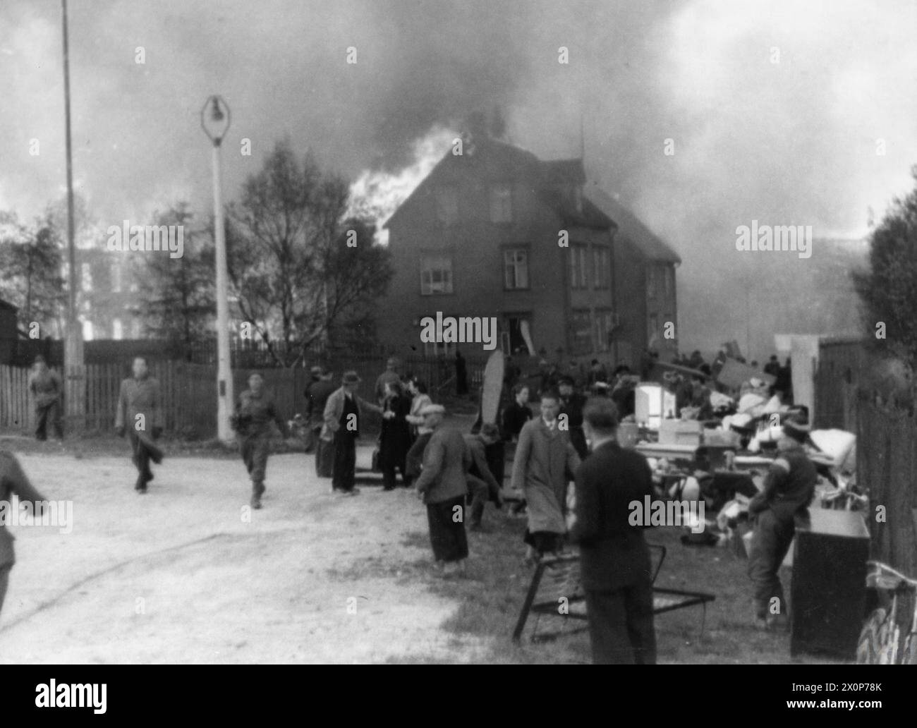 L'INVASION ALLEMANDE DE LA NORVÈGE, 1940 - les civils norvégiens récupèrent leurs meubles et leurs biens dans des bâtiments en feu à Narvik Banque D'Images