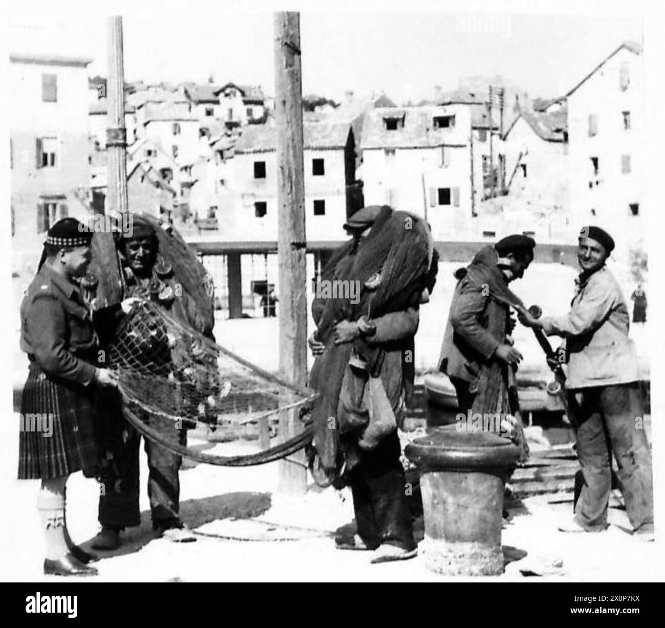 Le major R. Russell inspecte les filets de pêche avec un pêcheur local à Split, supervisant les fournitures de secours agricoles et halieutiques fournies par la Grande-Bretagne à la Yougoslavie. Banque D'Images