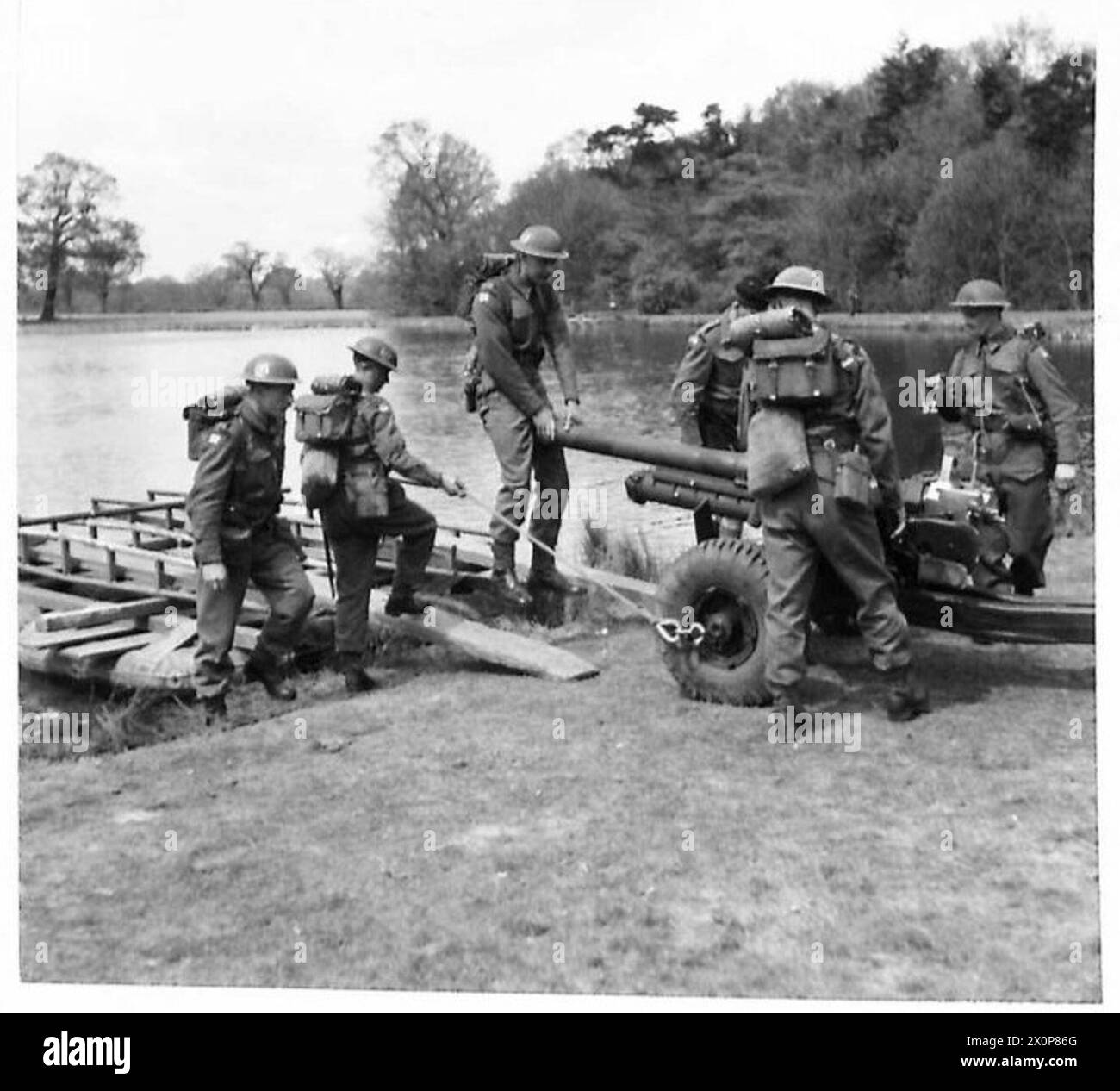 Les hommes chargent un canon antichar de 6 livres sur un bateau d'assaut. Négatif photographique, armée britannique. Banque D'Images