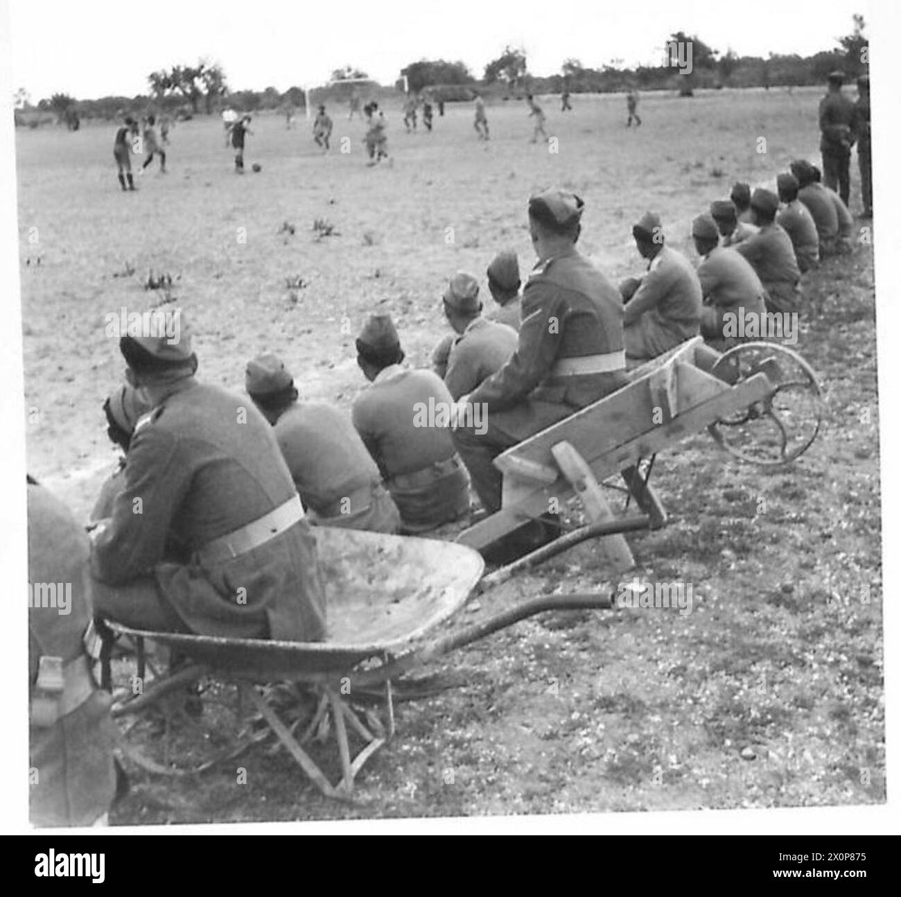 Les spectateurs d'un match de football à Chypre utilisent des brouettes comme sièges. Des négatifs photographiques documentent les loisirs et les activités récréatives du personnel de l'armée britannique. Banque D'Images