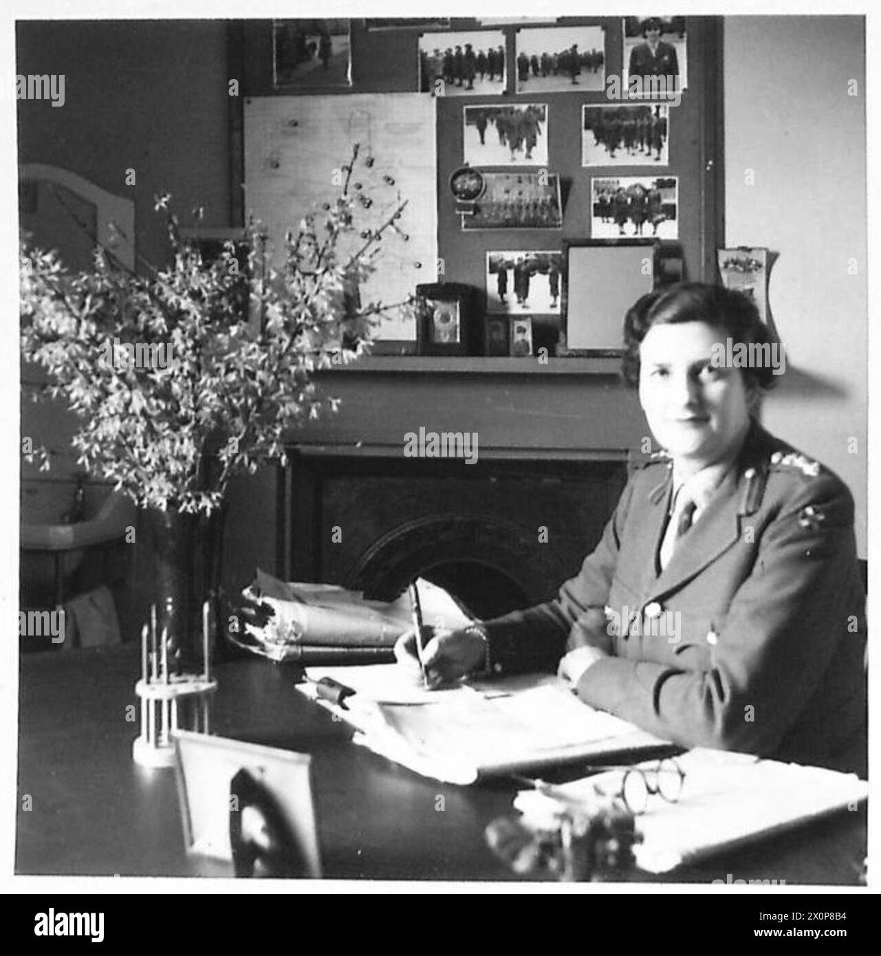 Le contrôleur G.M. Heaton de l'A.T.S. continue un record militaire de longue date pendant qu'il est assis à son bureau. La scène est capturée dans un négatif photographique. Banque D'Images Le contrôleur G.M. Heaton de l'A.T.S. continue un record militaire de longue date pendant qu'il est assis à son bureau. La scène est capturée dans un négatif photographique. Banque D'Images