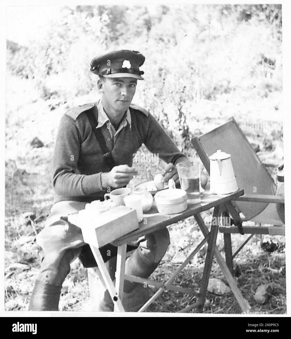 Un officier de cavalerie britannique prend son petit déjeuner, y compris des œufs durs, pendant l'avancée en Syrie, documenté dans un négatif photographique de l'armée britannique. Banque D'Images