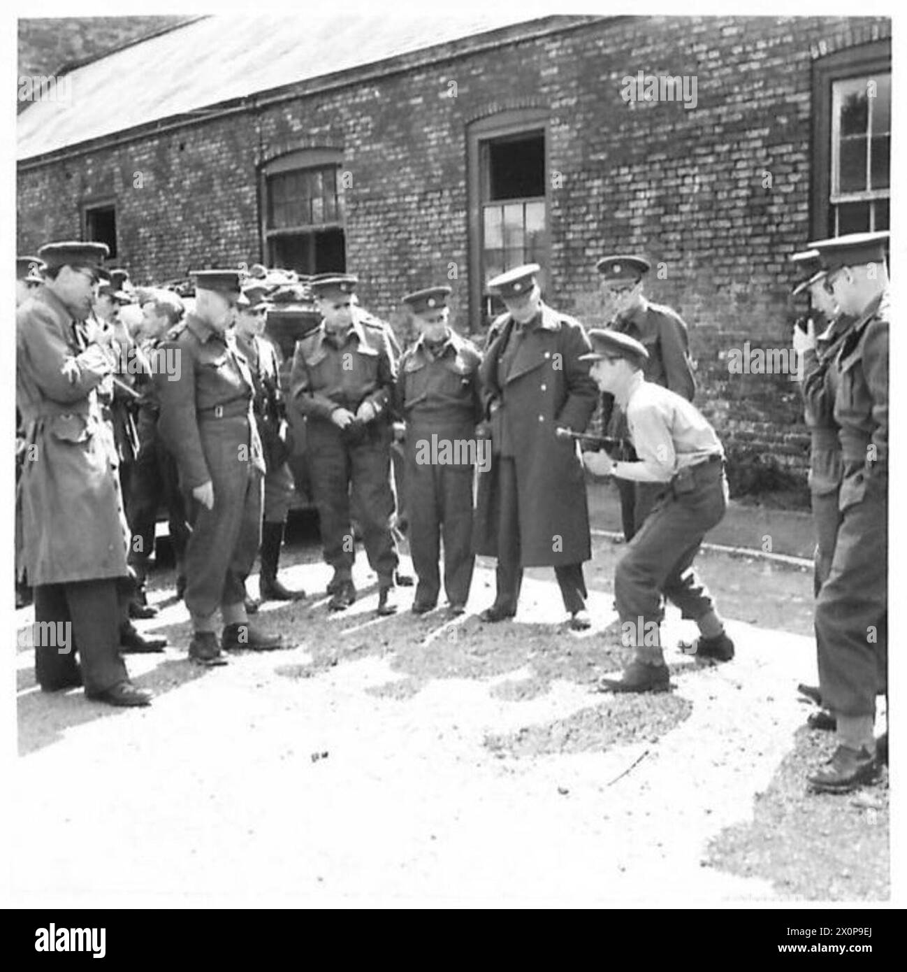 Les correspondants de guerre provinciaux suivent le cours d'assaut à l'école de bataille et reçoivent une démonstration du canon Tommy d'un instructeur. Banque D'Images