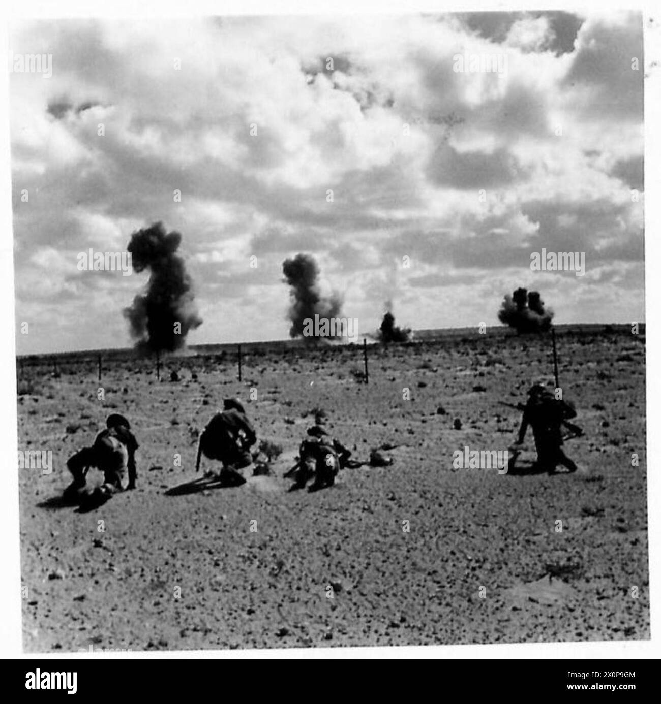 Les troupes avancent pendant que des mines terrestres explosent en arrière-plan lors d'une opération militaire. Banque D'Images