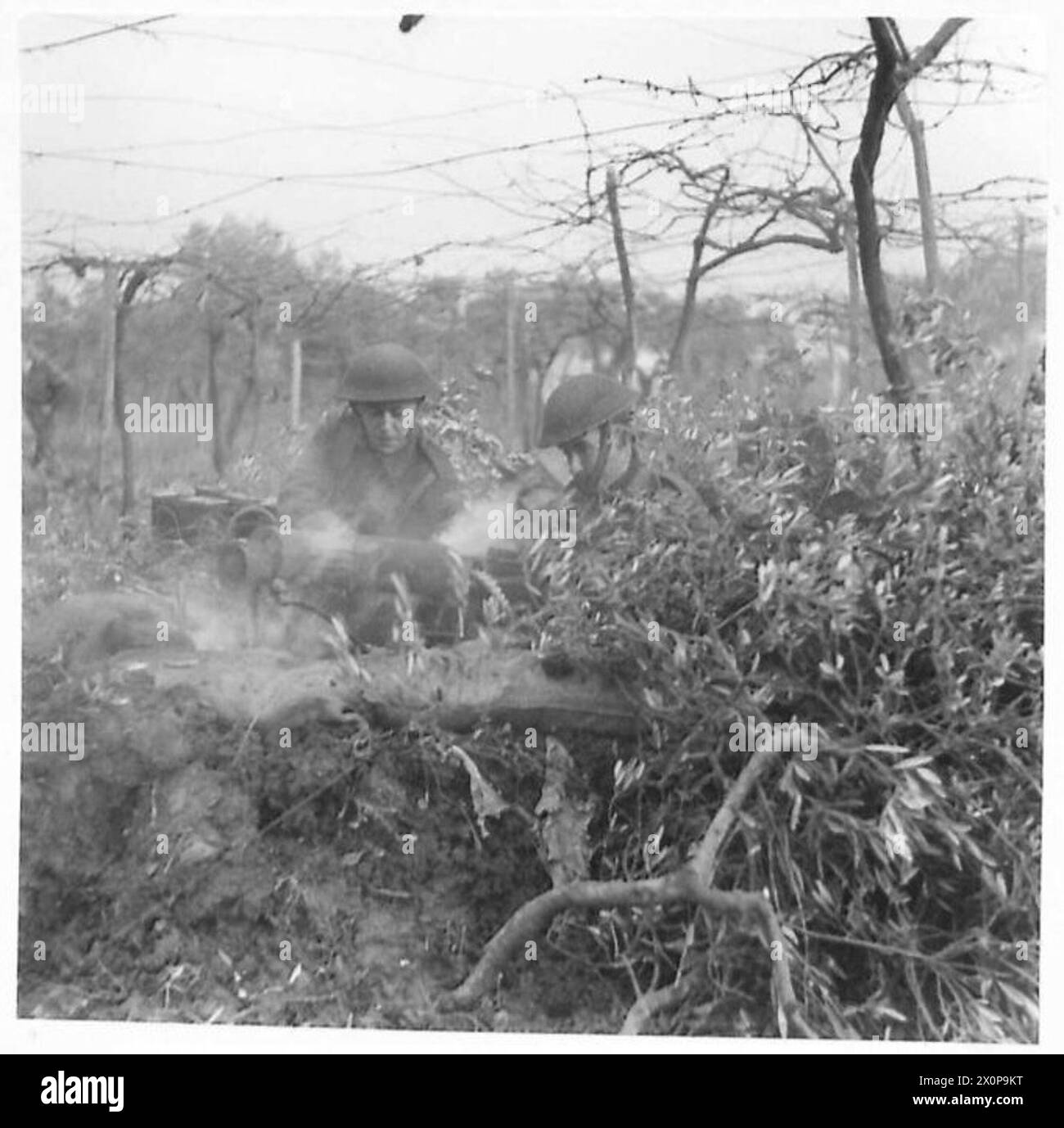 Cape Breton Highlanders manipule une mitrailleuse lourde Vickers dans l'action côtière, avec des cartouches usagées visibles dans les fosses d'armes. Négatif photographique, armée britannique. Banque D'Images