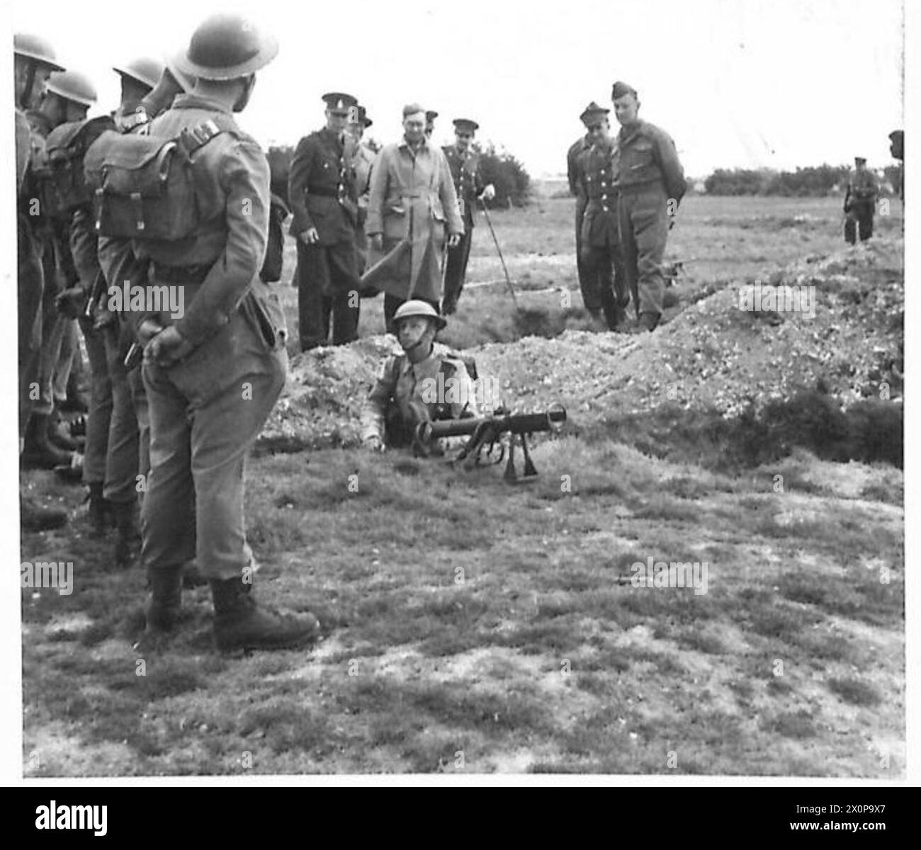 Sir James Grigg, secrétaire d'État à la Guerre, observe une arme antichar PIAT lors d'une visite des troupes de l'armée britannique. Banque D'Images