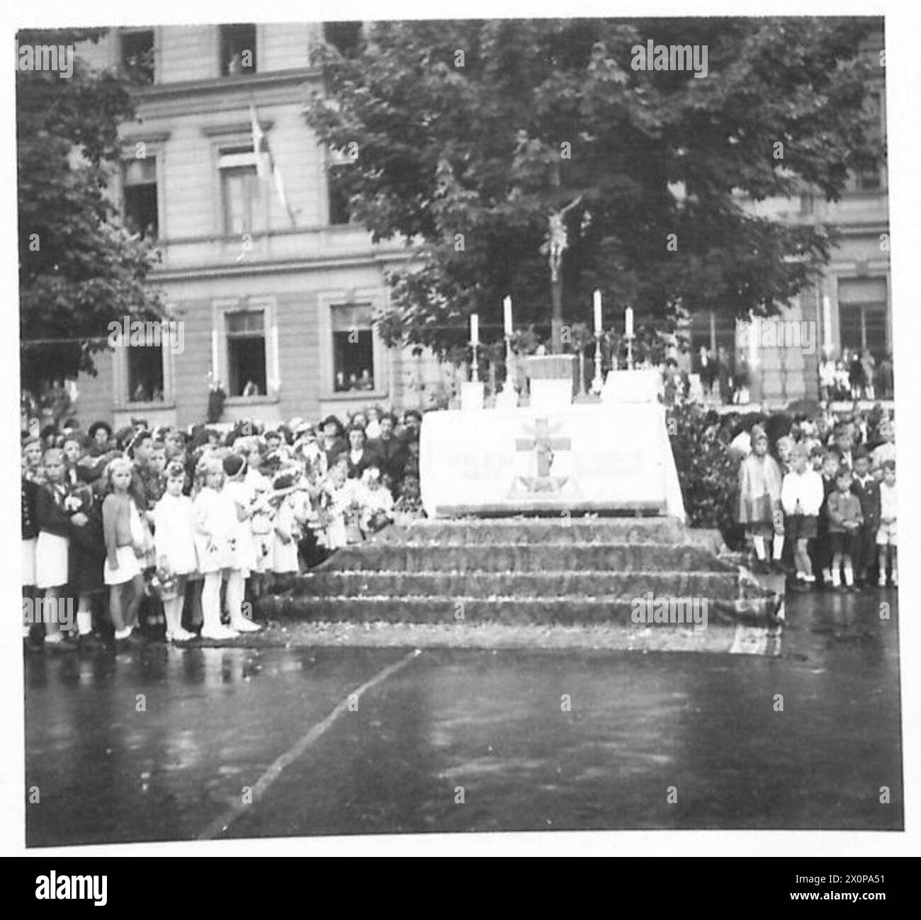 Les enfants dirigent une procession du Corpus Christi à Klagenfurt, en Autriche, en arrosant des fleurs sur les marches de l'autel dans le cadre de la cérémonie religieuse. Banque D'Images