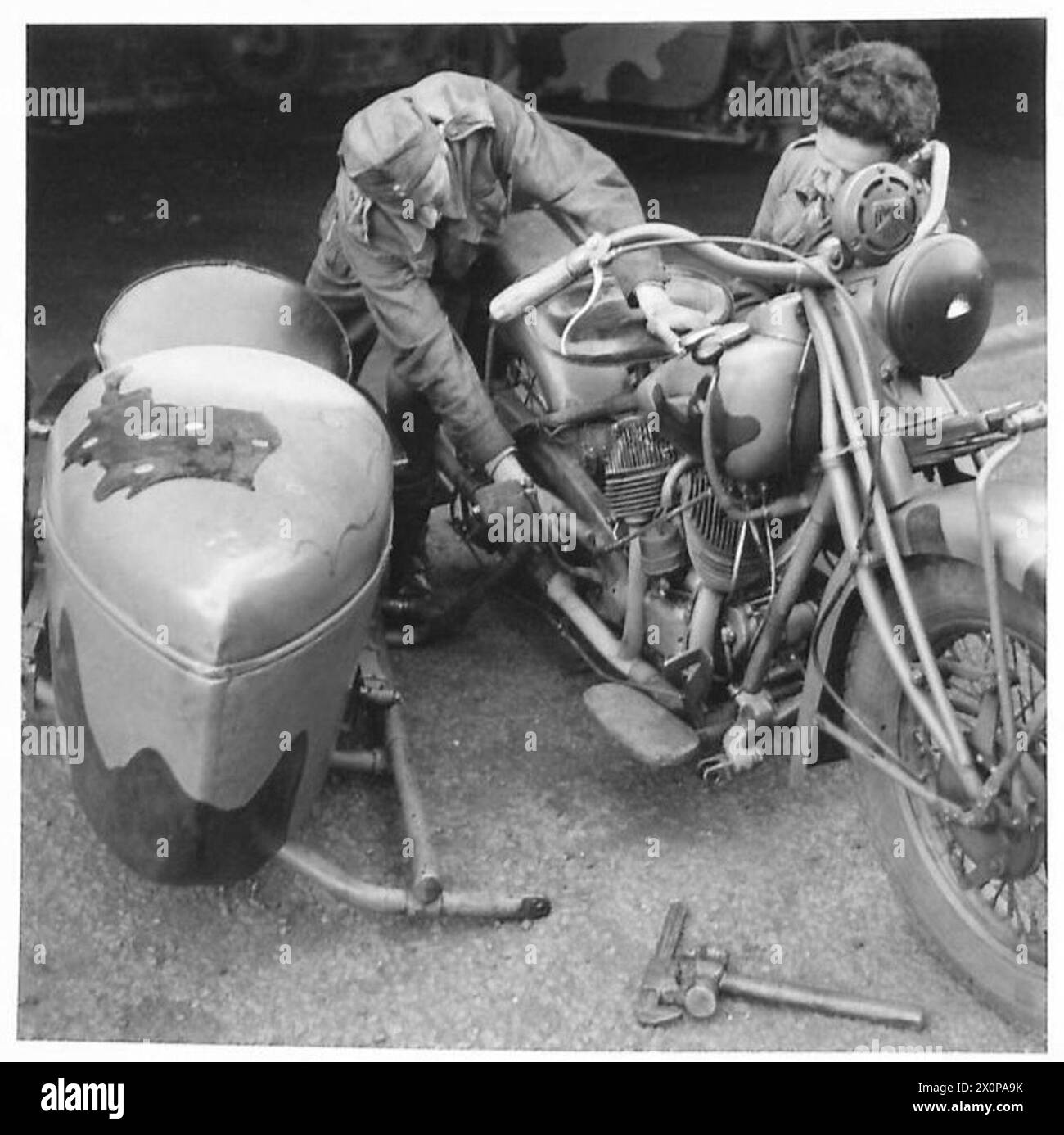 L'ARMÉE POLONAISE EN GRANDE-BRETAGNE, 1940-1947 - mécanicien vérifiant une combinaison de motocyclettes dans le moteur. Notez une carte de la Pologne, divisée entre l'Allemagne nazie et l'Union soviétique, peinte sur le side-car comme une partie du camouflage de la moto. M. Don Sutton, représentant l'American Newspaper Enterprise Association, a visité certaines unités du 1er corps polonais en Écosse en juillet 1942. Au cours de sa visite, il a été témoin de certaines activités quotidiennes des troupes polonaises. La visite de M. Sutton (et les photographies ci-dessous) visait à faire connaître l'effort de guerre polonais aux États-Unis. Noir et blanc, Armée polonaise, Pol Banque D'Images