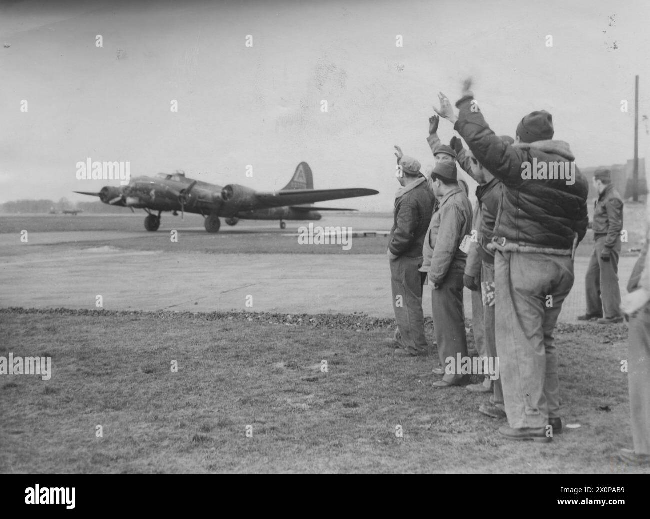 HUITIÈME FORCE AÉRIENNE DES ÉTATS-UNIS EN GRANDE-BRETAGNE, 1942-1945 - le personnel du 91st Bomb Group a fait une vague vers une forteresse volante B-17 (OR-M, numéro de série 42-29739) surnommée 'The Village Flirt' à son retour à Bassingbourn, après un raid sur Berlin.image estampillée au revers: 'passé pour publication' [timbre].'Planet News' [timbre].légende imprimée au verso : 'BIENVENUE DE BERLINPHOTO MONTRE:- les équipages au sol et les dépliants encouragent comme une forteresse volante 'le village Flirt' taxies le long de la piste après avoir attaqué avec succès le cœur de Berlin sans rencontrer aucune opposition de combattant.Pool 10 mars 1944.Air(Boe Banque D'Images