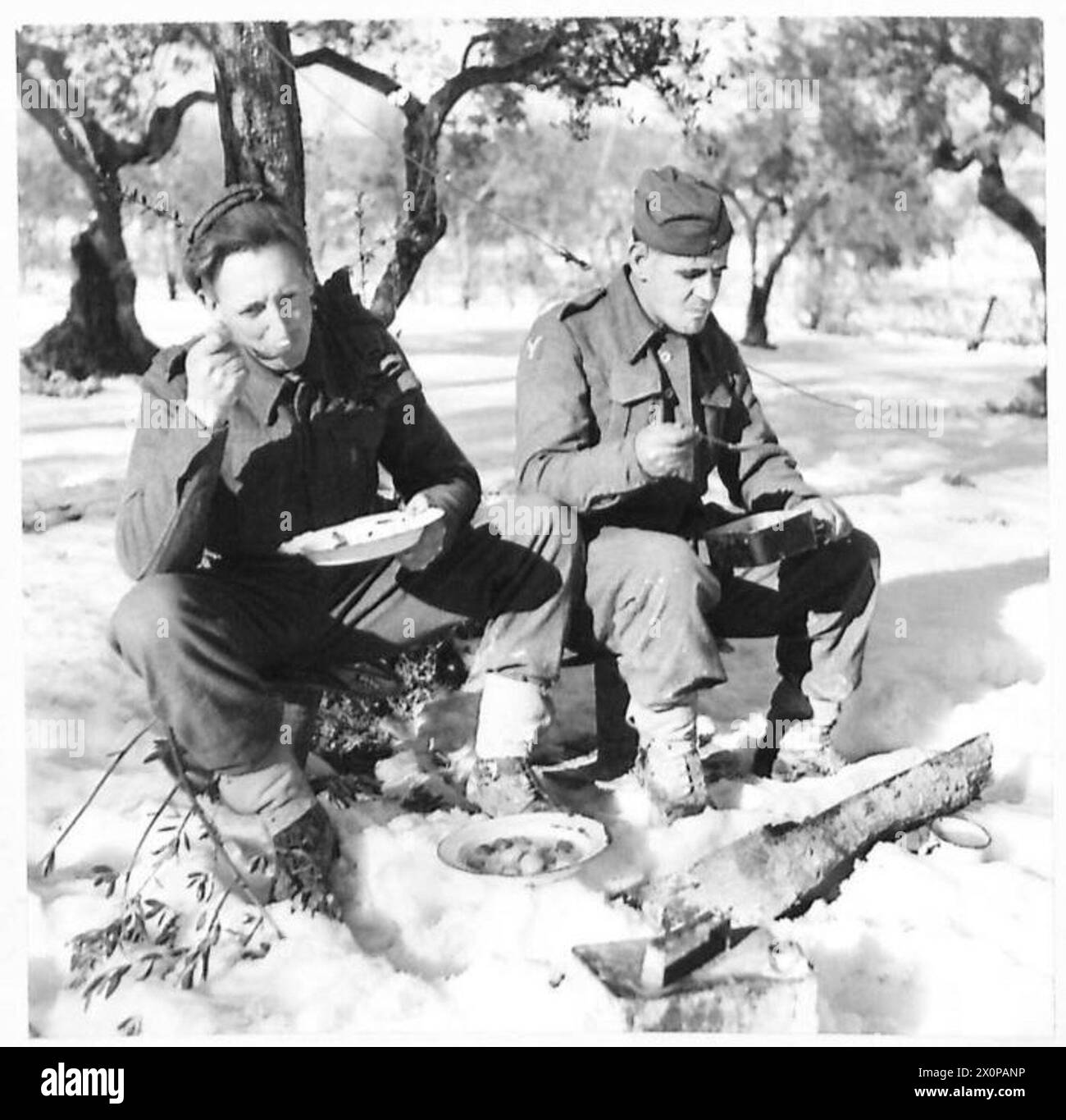 Pte. J. Stutter et Pte. E. Cambridge de la huitième armée mangent leur dîner dans la neige lors de la visite du général Freyburg à la brigade 15 en Italie. Banque D'Images
