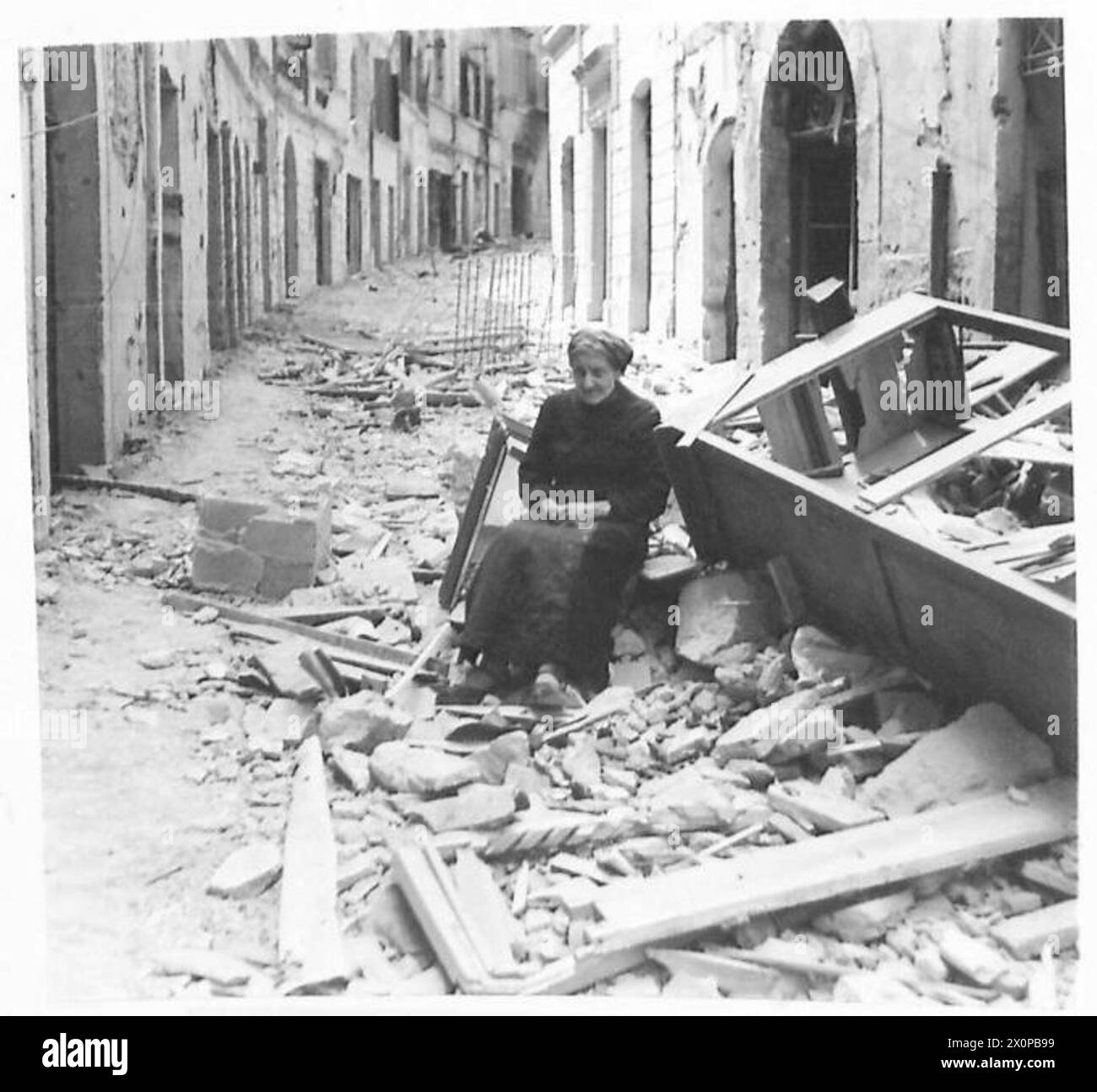 CINQUIÈME ARMÉE : CHUTE DE VELLETRI - une vieille dame de 74 ans, qui s'est cachée dans une cave pendant le bombardement de la ville. Elle est vue assise sur un tas de débris à l'extérieur de sa maison. Négatif photographique, Armée britannique Banque D'Images
