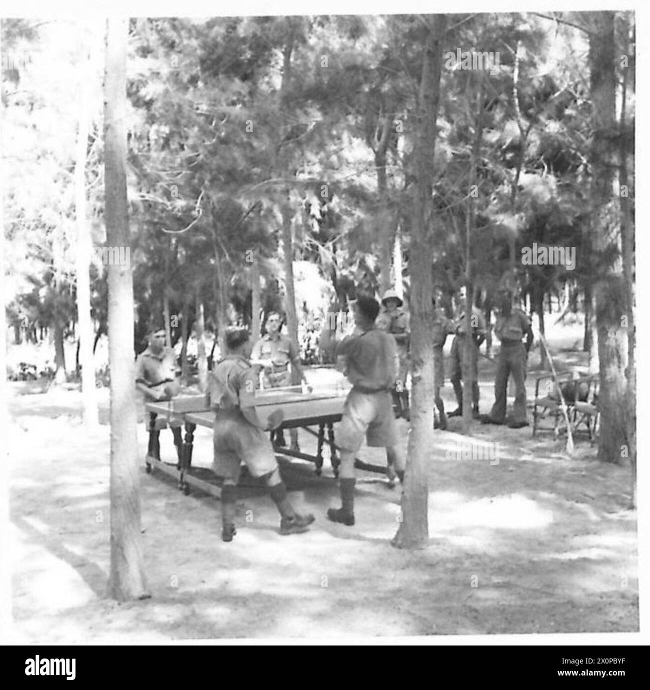 Le personnel joue au tennis de table sous les arbres pendant une période récréative documentée à la demande du major Ruston. Négatif photographique de l'armée britannique. Banque D'Images