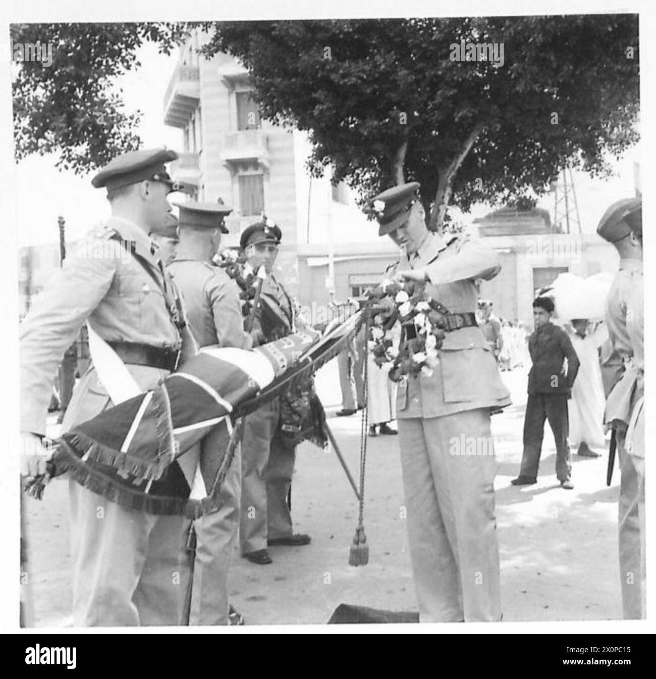 Pendant les célébrations de la fête de George au Caire, le personnel de l'armée britannique ajuste les roses sur les couleurs avant la marche passée. Banque D'Images