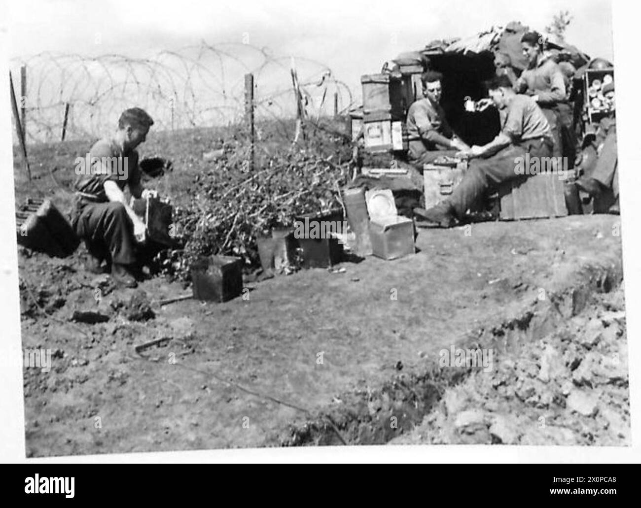 Le personnel de cuisine de la compagnie d du bataillon irlandais à Anzio Bridgehead prépare une ration de viande spéciale pour célébrer le jour de Patrick. Négatif photographique, armée britannique. Banque D'Images