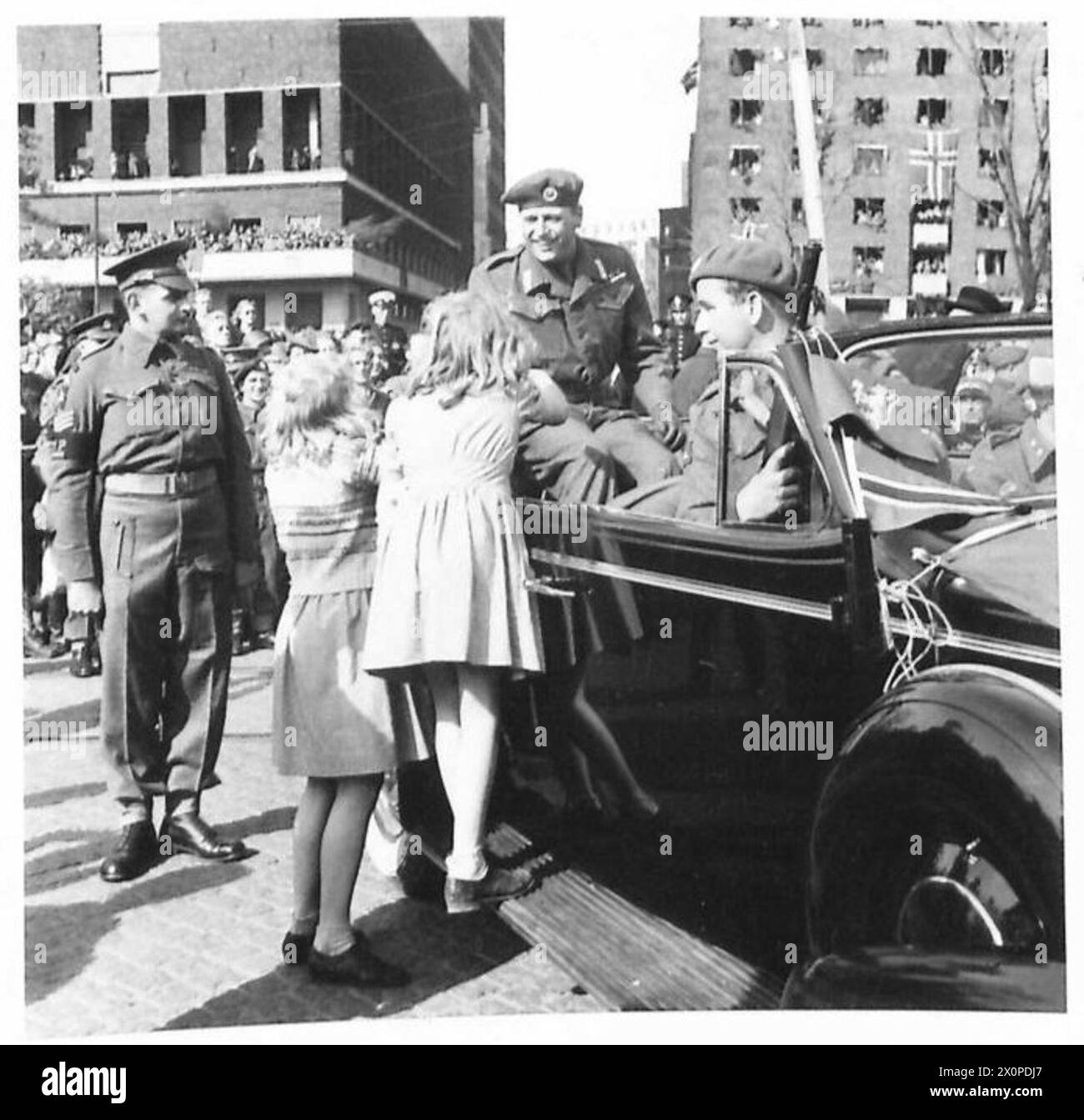 Deux filles norvégiennes saluent le prince héritier Olav alors qu'il retourne en Norvège, capturé au quai par l'armée britannique, 21e groupe d'armées. Banque D'Images