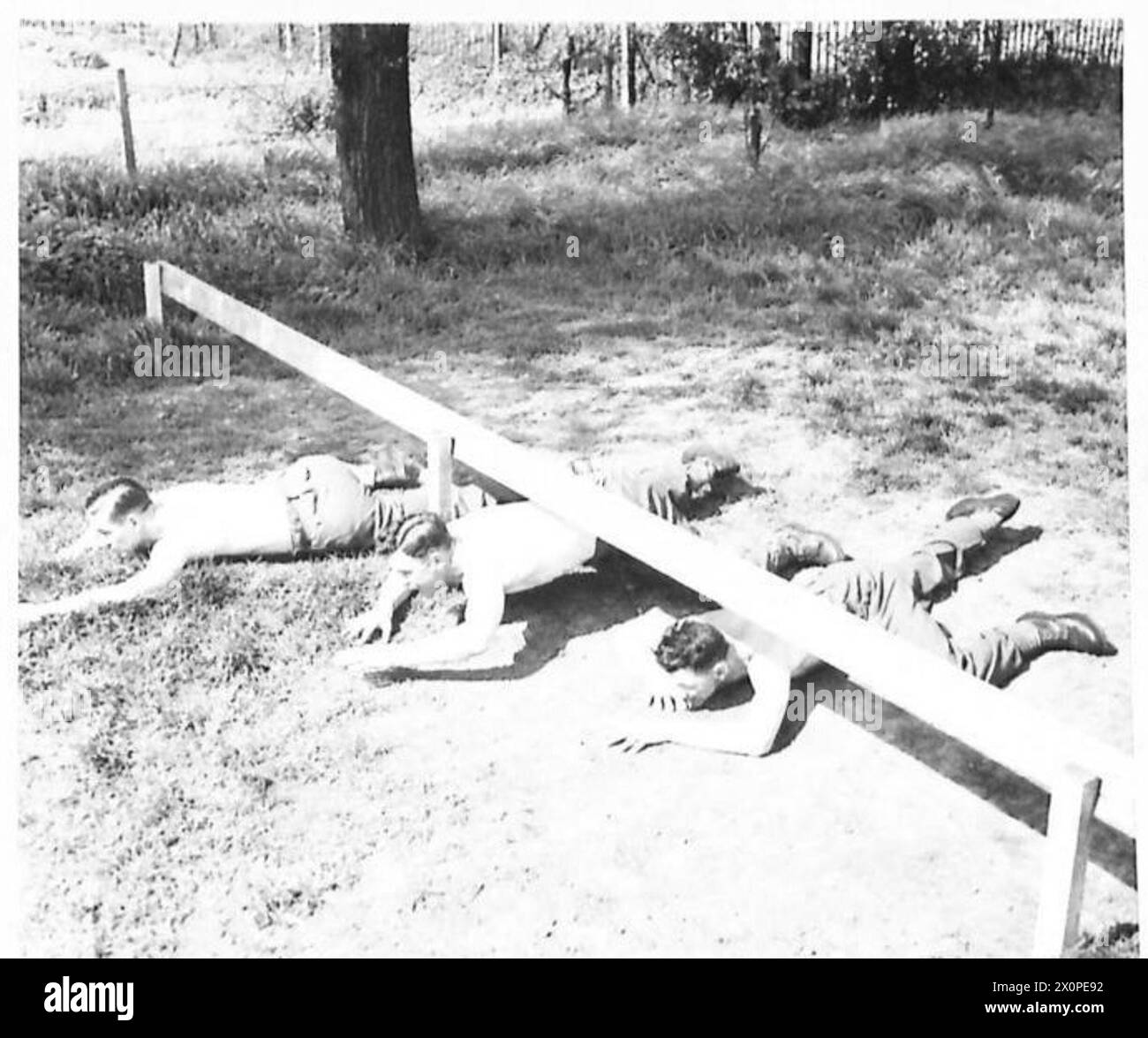 ÉCOLE D'ENTRAÎNEMENT PHYSIQUE À HENDON - ramper sous la barre basse. De gauche à droite : position avant le mouvement vers l'avant ; mouvement vers l'avant et position incorrecte du bras et de la jambe. Négatif photographique, Armée britannique Banque D'Images