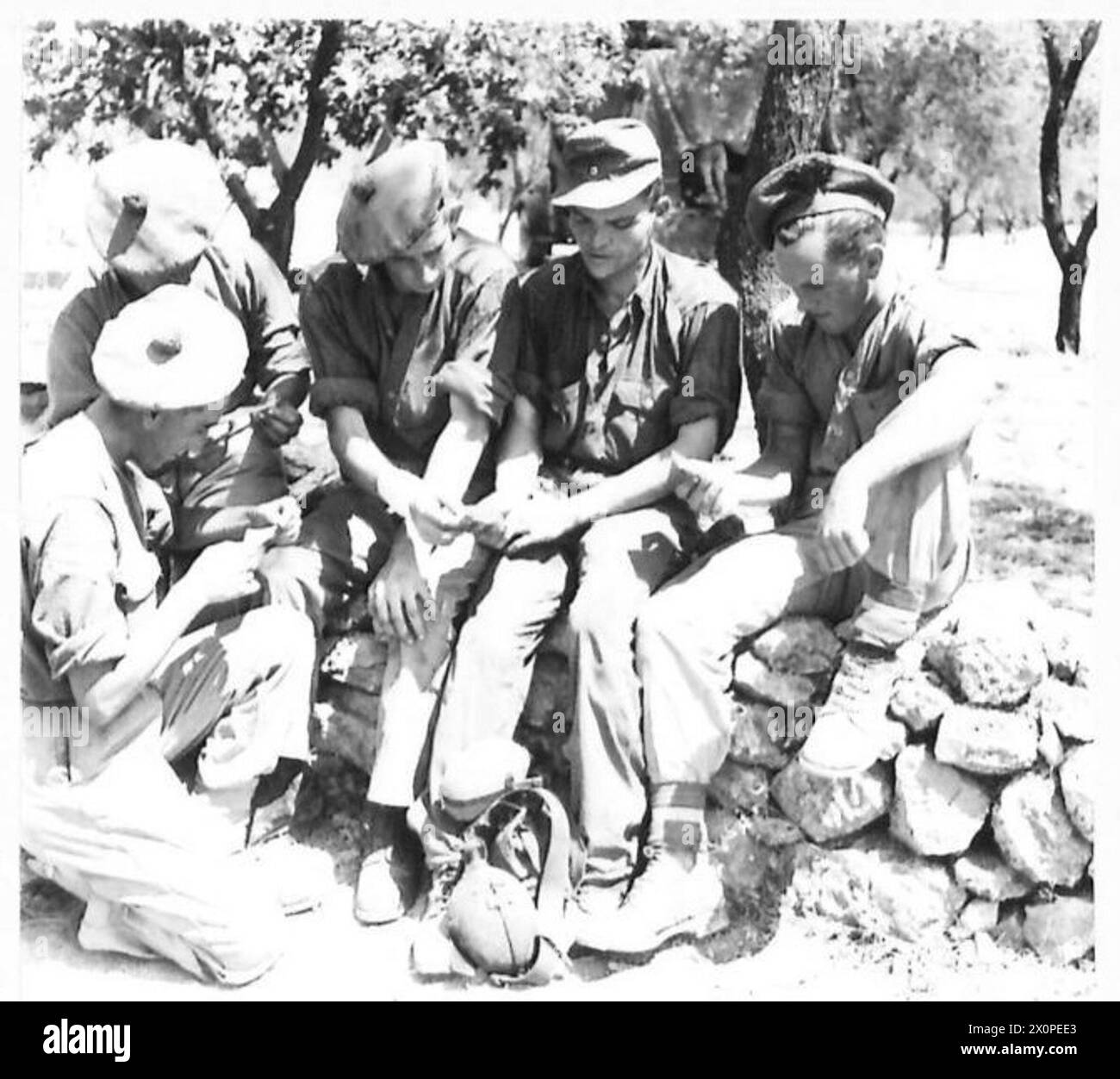 Prisonnier allemand du régiment Herman Goering échange des photographies avec des hommes de la division Highland. Négatif photographique, armée britannique. Banque D'Images