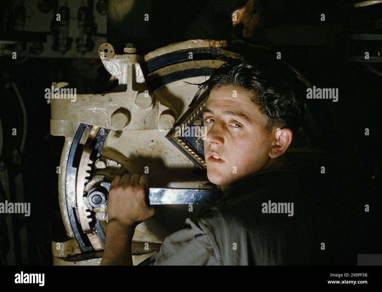 Une cote actionne le levier pour ouvrir la porte du tube torpille no 2 sur le sous-marin HMS Tribune en 1942. Banque D'Images