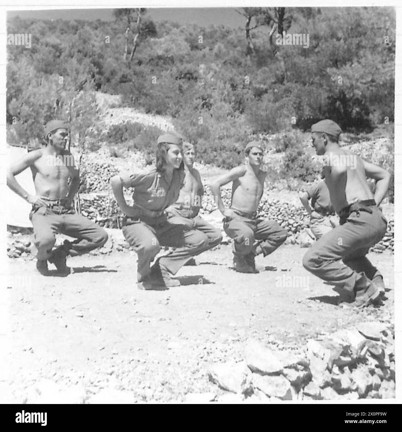 Séance d'entraînement physique matinale avec des hommes sur l'île de Viz dans le cadre des activités quotidiennes d'une jeune fille partisane. Négatif photographique, armée britannique. Banque D'Images