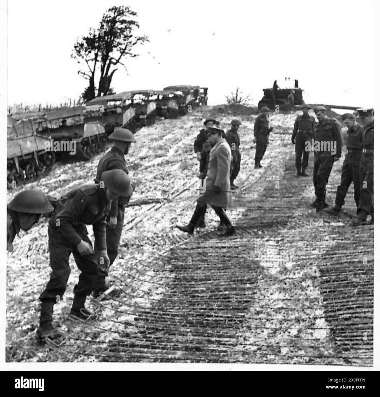 SA MAJESTÉ LE ROI VISITE LES TROUPES D'INVASION - les troupes posant une route câblée sur un sol meuble sont visitées par sa Majesté. Négatif photographique, Armée britannique Banque D'Images