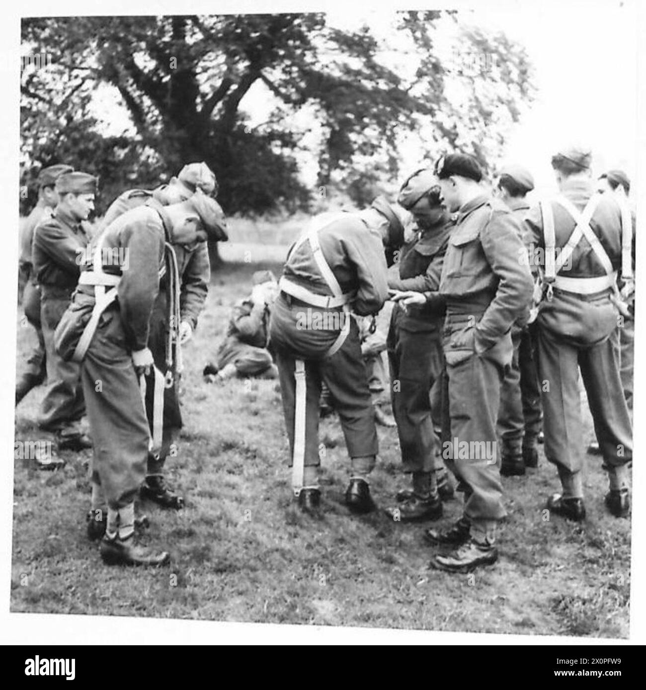 Les parachutistes stagiaires ajustent leur harnais de parachute avant un saut contrôlé d'une tour à Elie, Fifeshire. L'exercice fait partie de la formation de la 4e brigade de fusiliers du cadre, démontrant les techniques d'atterrissage appropriées sous la supervision du général Sikorski. Banque D'Images