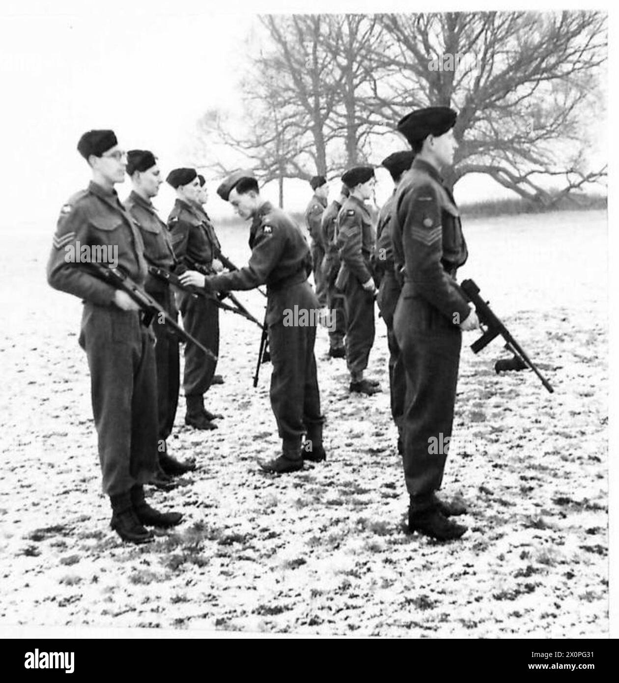 Les commis de paye de l'armée britannique et les soldats effectuent une inspection d'un canon Tommy. Banque D'Images