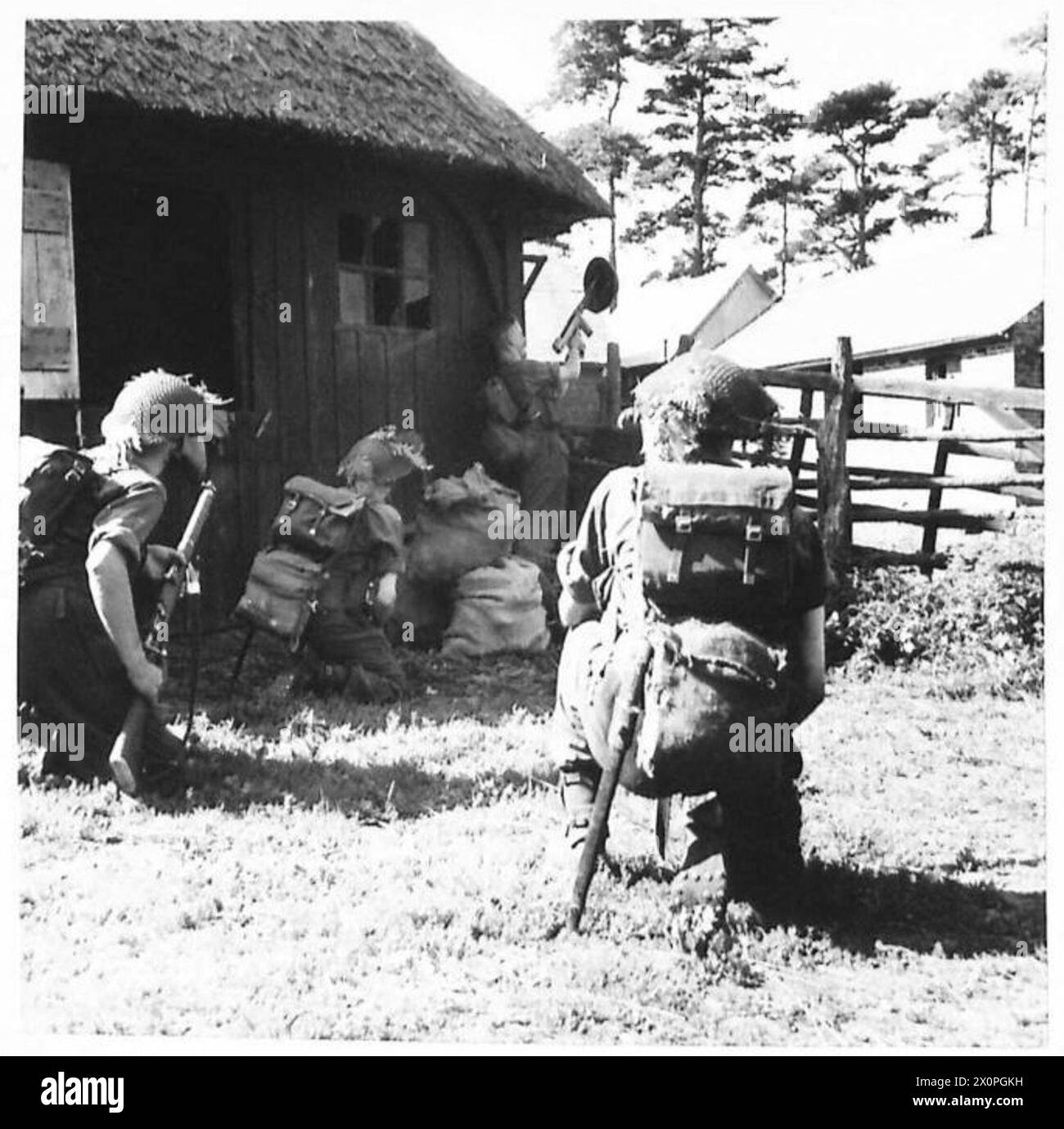 Un soldat utilise un pistolet Tommy et tire des tirs ennemis tout en nettoyant les défenseurs restants dans une ferme. Banque D'Images