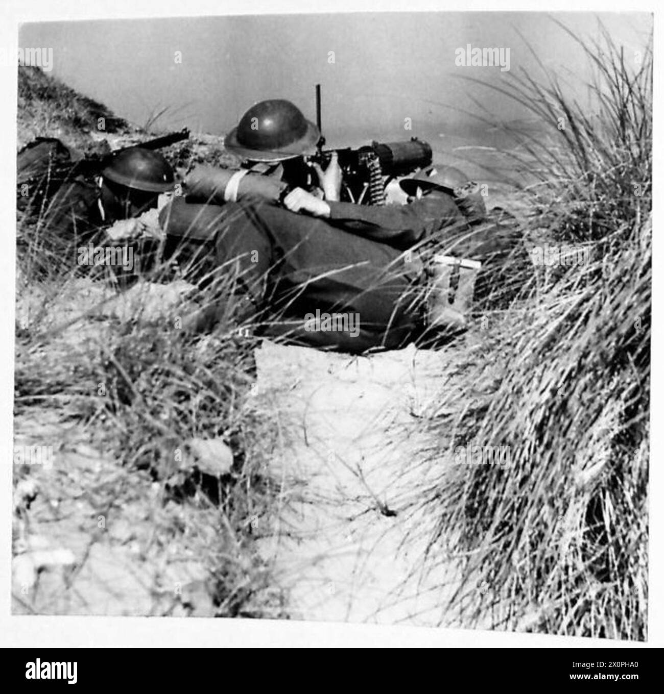 ENTRAÎNEMENT AUX MITRAILLEUSES - Un poste de mitrailleuse dans l'herbe rugueuse des dunes de sable sur la côte nord-irlandaise. Négatif photographique, Armée britannique Banque D'Images