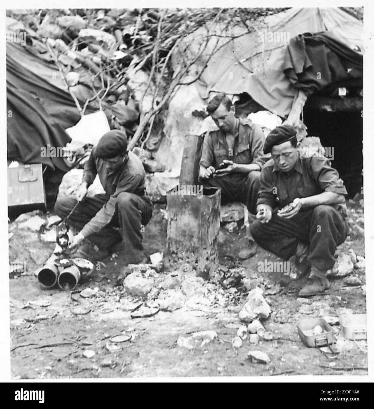 Les équipes de mortier coulent des badges de chapeau dans de l'argile en utilisant du métal fondu provenant des chapeaux de sécurité des bombes de mortier entre les opérations de tir. Banque D'Images