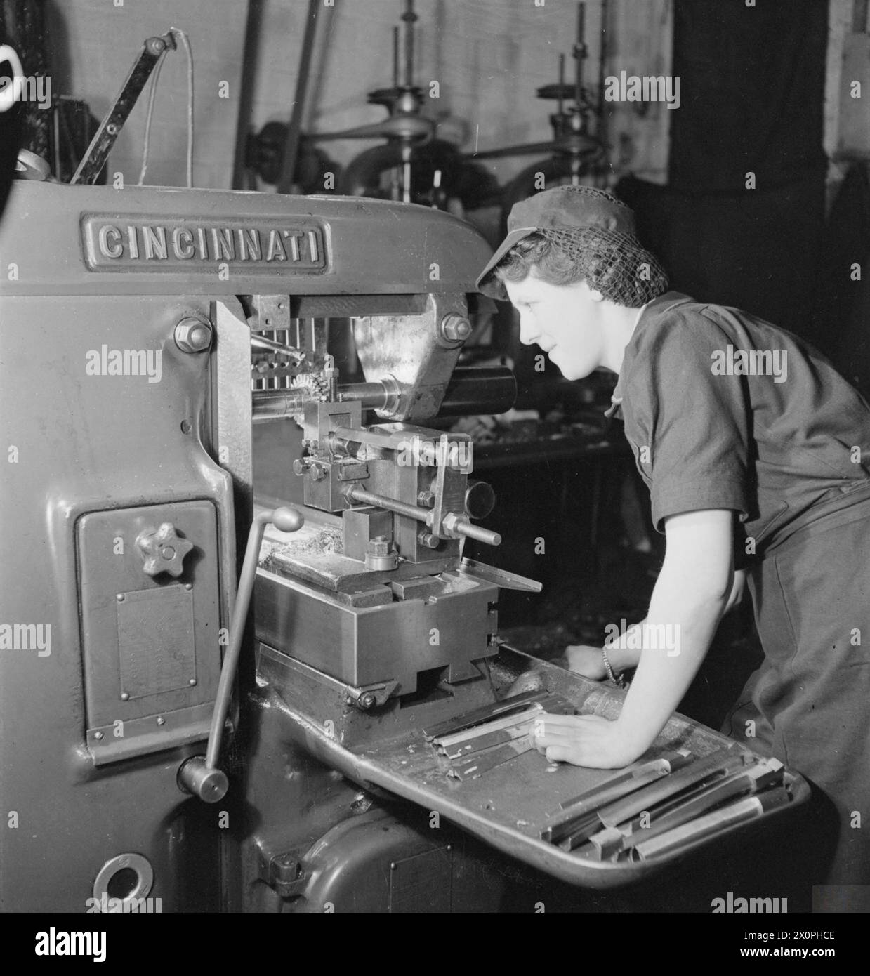 FEMMES OUVRIÈRES DE GUERRE EN GRANDE-BRETAGNE PENDANT LA SECONDE GUERRE MONDIALE - Une travailleuse métallurgique finit par se tendre à une précision de .001 pouces à l'aide d'une fraiseuse Cincinnati (capacité de 1-12 pouces). Les aubes montrées étaient des aubes de turbine Impulse de 1 pouce en acier inoxydable Hecla Banque D'Images