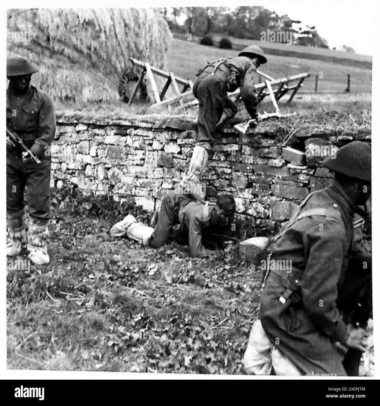 Les patrouilleurs utilisent la couverture et le positionnement tactique avec des armes à feu lorsqu'ils escaladent un mur pendant une opération de combat. Banque D'Images