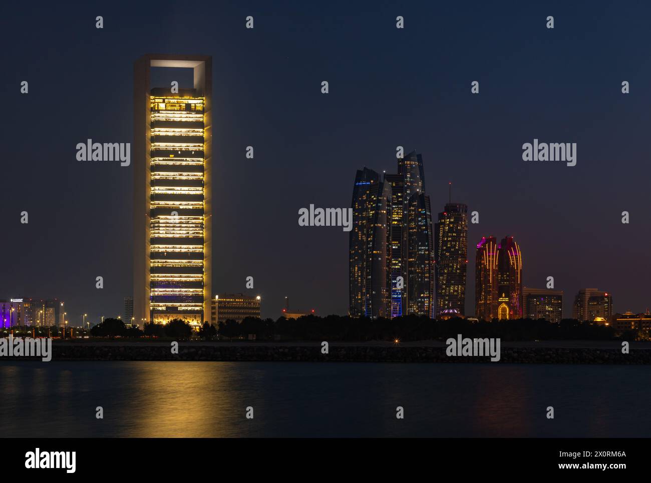 Une photo des tours Etihad et du siège de la compagnie pétrolière nationale d'Abu Dhabi la nuit. Banque D'Images