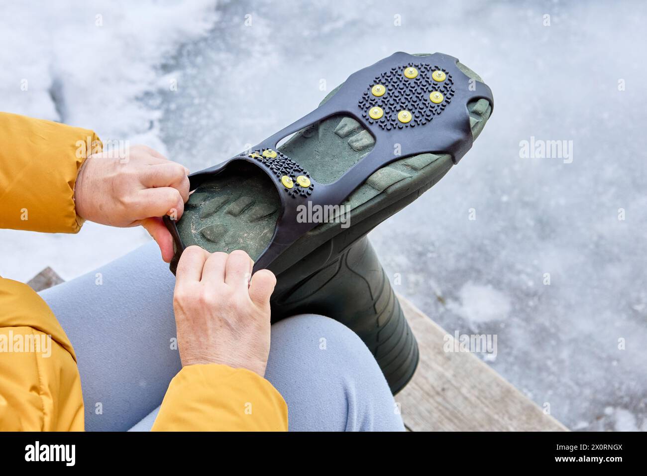 Installation de poignées antidérapantes avec crampons sur le bas de la chaussure. Banque D'Images