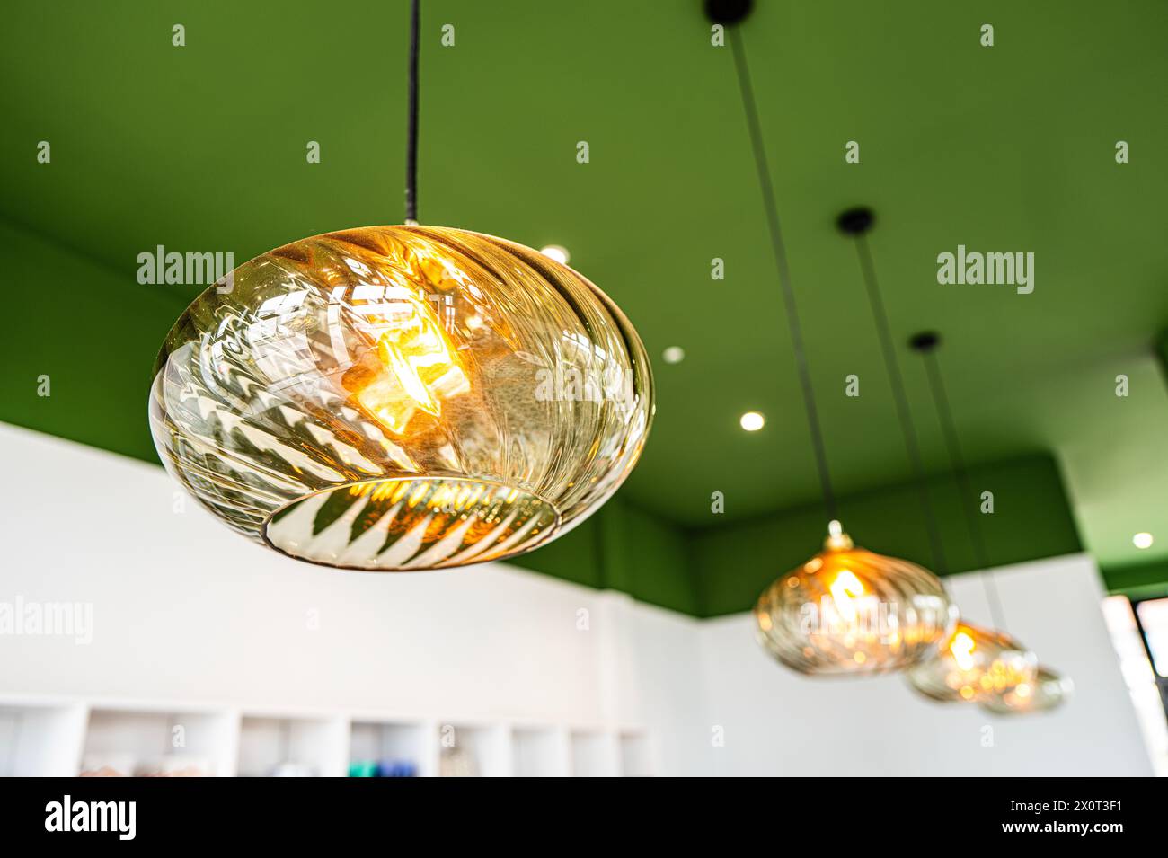 Plafonnier orné de verre opalin dans un café avec plafond vert Banque D'Images