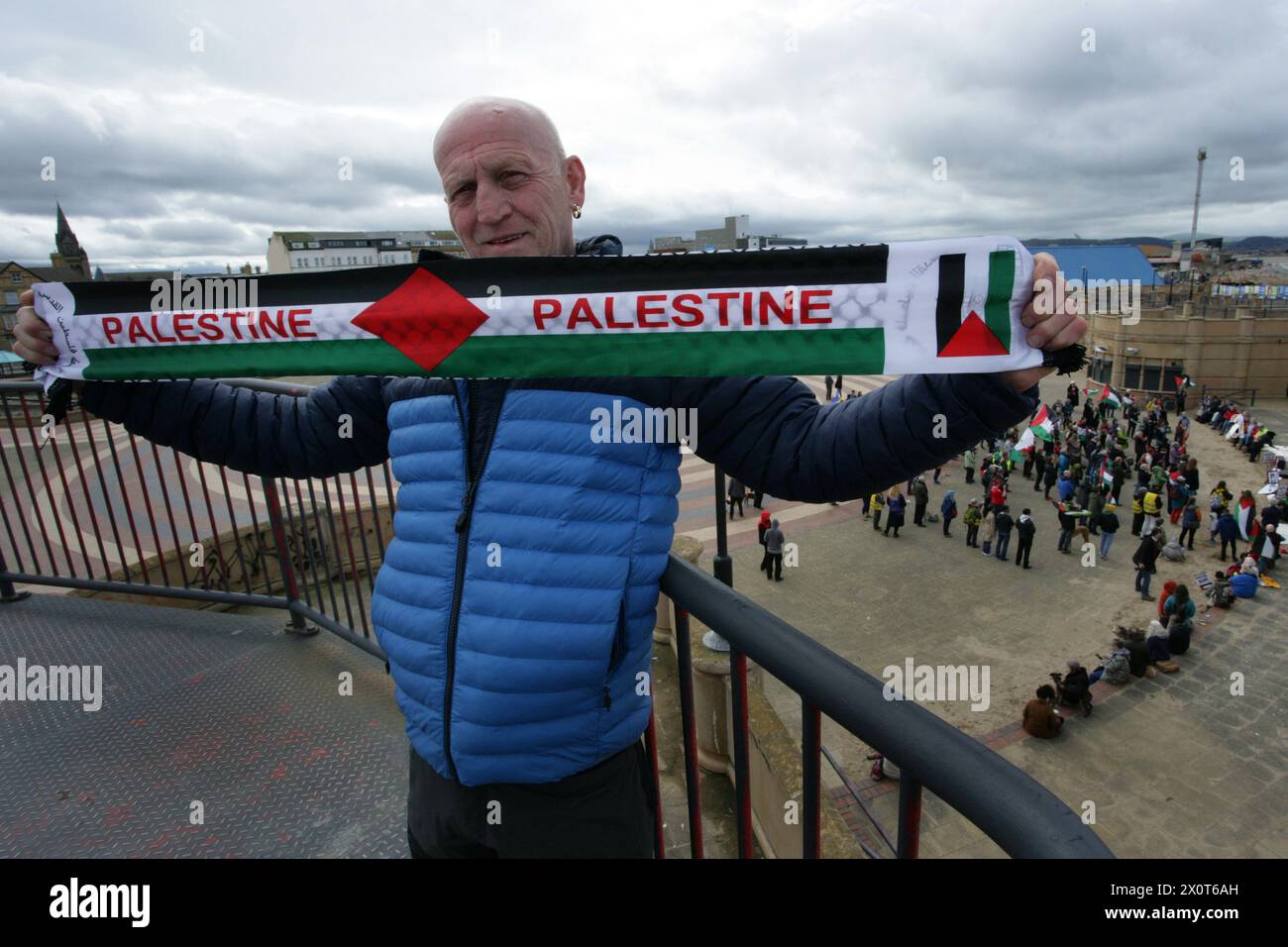 Rhyl, Royaume-Uni. 13 avril 2024. Un manifestant tient une écharpe palestinienne pendant la manifestation. Plus de 150 partisans pro-palestiniens de partout au pays de Galles ont manifesté dans les rues pour exiger un cessez-le-feu à Gaza et mettre fin au génocide. Crédit : SOPA images Limited/Alamy Live News Banque D'Images