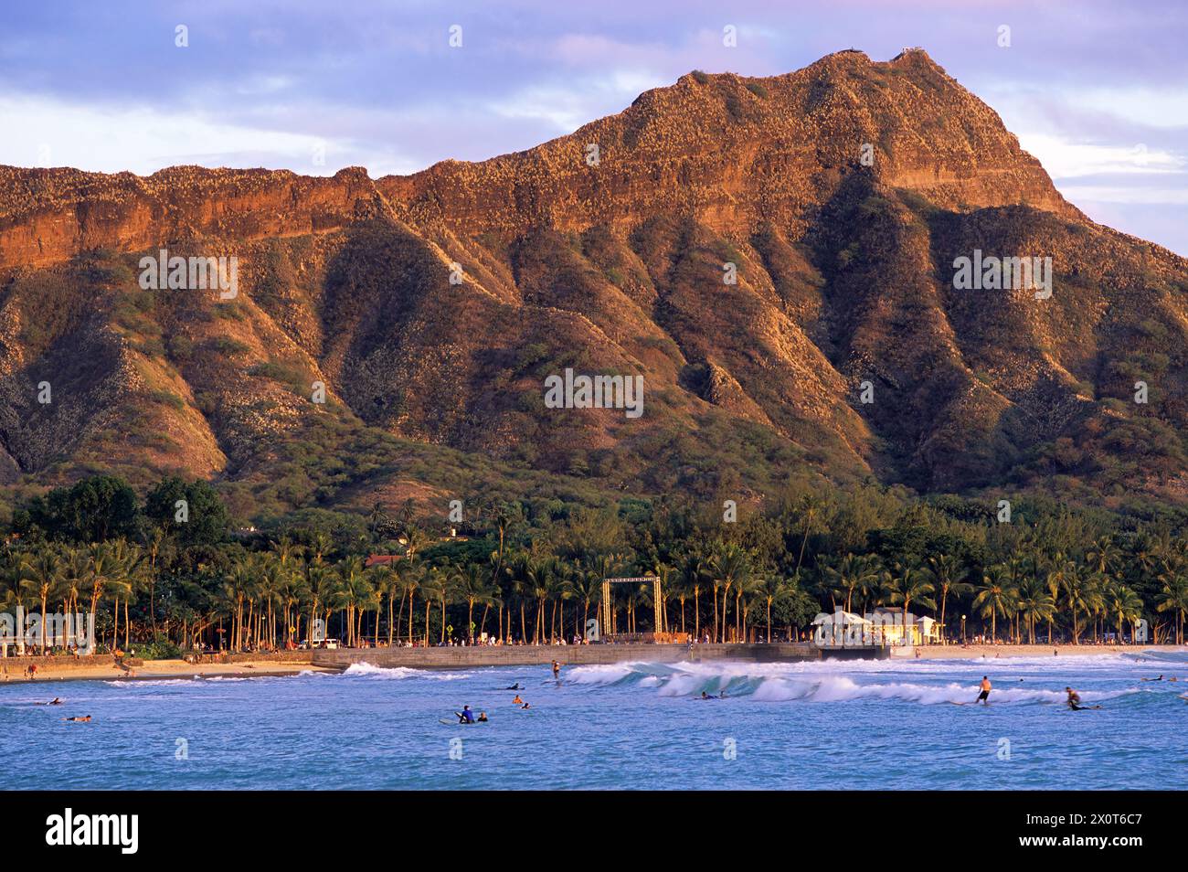 Oahu, Hawaï, États-Unis - Waikiki Swimmers, Surfers at Sunset, Honolulu. Tête de diamant en arrière-plan. Banque D'Images