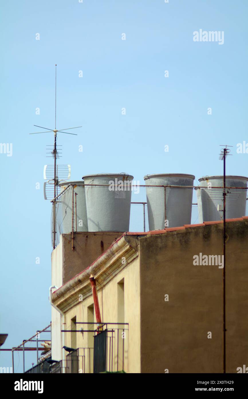 Des réservoirs gris d'eau s'élèvent contre un ciel clair, capturant l'essence du paysage urbain. Banque D'Images